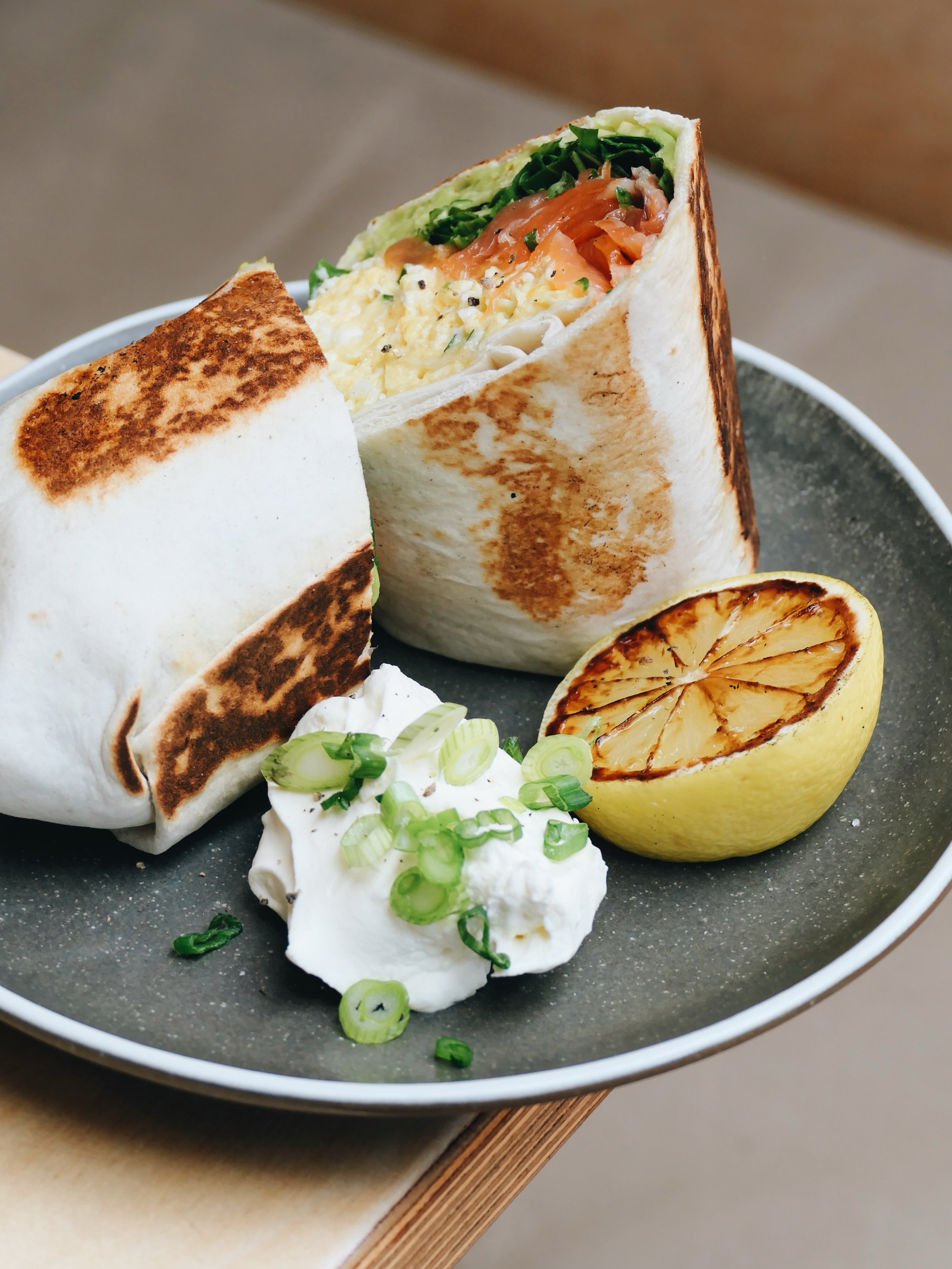 SMOKED SALMON BURRITO - Oak smoked salmon, crushed avocado, saut&eacute;ed potatoes, spring onion, baby spinach and scrambled egg in a floured tortilla with sour cream. Available from 8am - 2pm daily 👍✌️