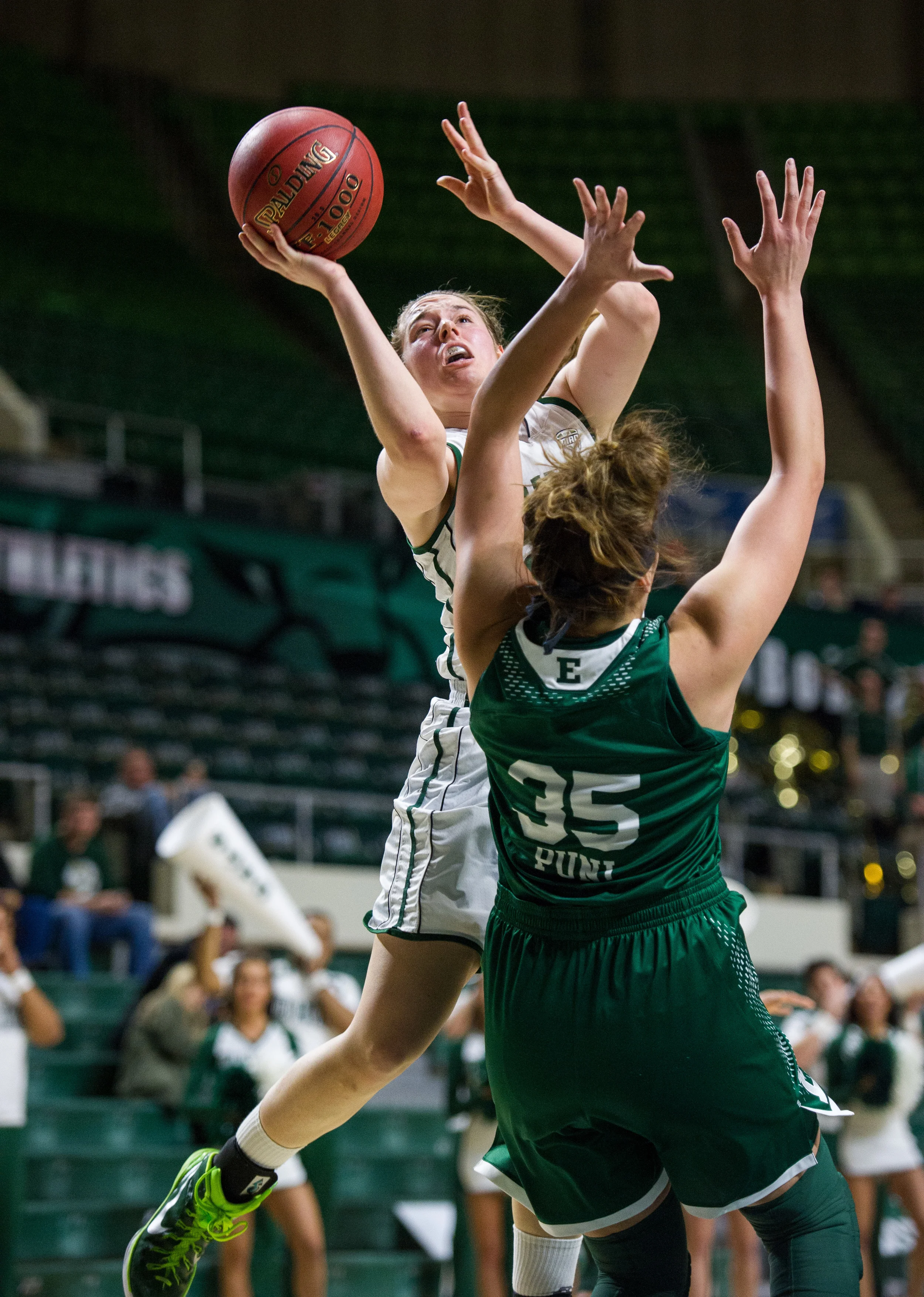 Ohio University sophomore Hannah Boesinger, of Hudson, Ohio, jumps up to the basket to score for the Bobcats amidst the guarding tactics of Eastern Michigan senior Brianna Puni, of St. Charles, Missouri. The Bobcats lost the game 73-61 at the Convocation Center in Athens, Ohio, on February 18, 2015.
