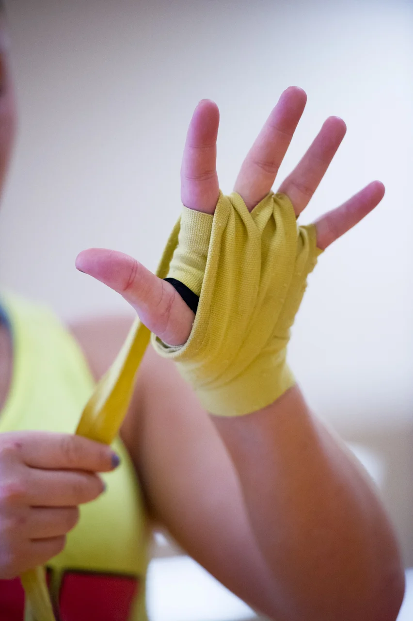 Sheeley applies hand wraps that she wears under her boxing gloves before her training session at the Ping Center on September 9, 2015, in Athens, Ohio. Hand wraps provide stability for the bones when boxing and prevent the skin from blistering. (©2015 Sarah Stier)