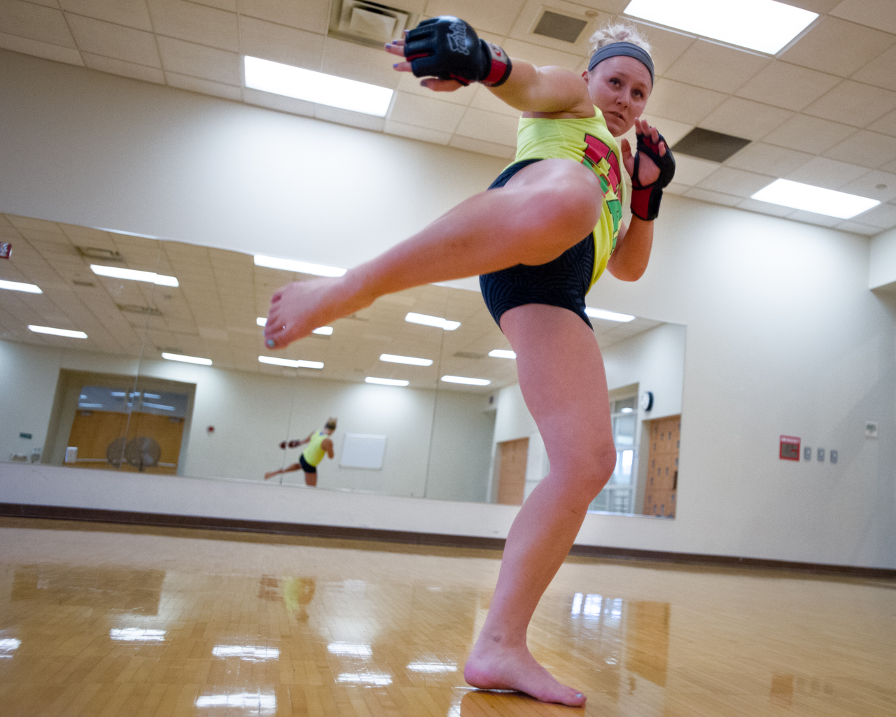Sheeley does a side kick while "shadow boxing" during her training session at the Ping Center on September 9, 2015, in Athens, Ohio. "The first time I got kicked in the face in practice, another female fighter kicked my nose and I got tears in my eyes but I got back up. After that I learned to start using the bruises as my trophies," says Sheeley. (©2015 Sarah Stier)