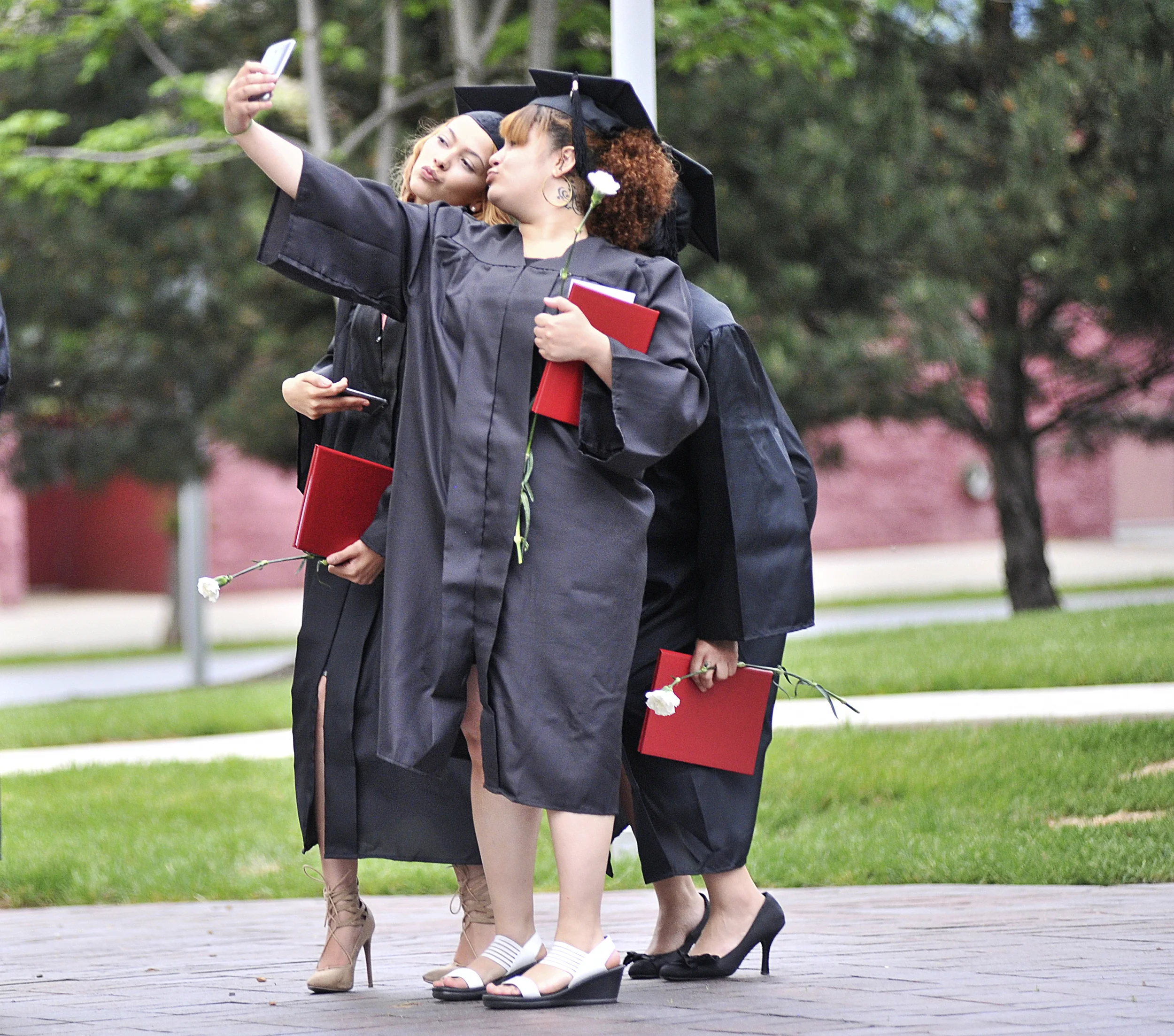 Demilee Alvarez, Imani Livingston, and Selenia Mendez take a photo together after Reading Area Community College's GED commencement ceremony on May 18, 2016, in Reading, Pennsylvania.