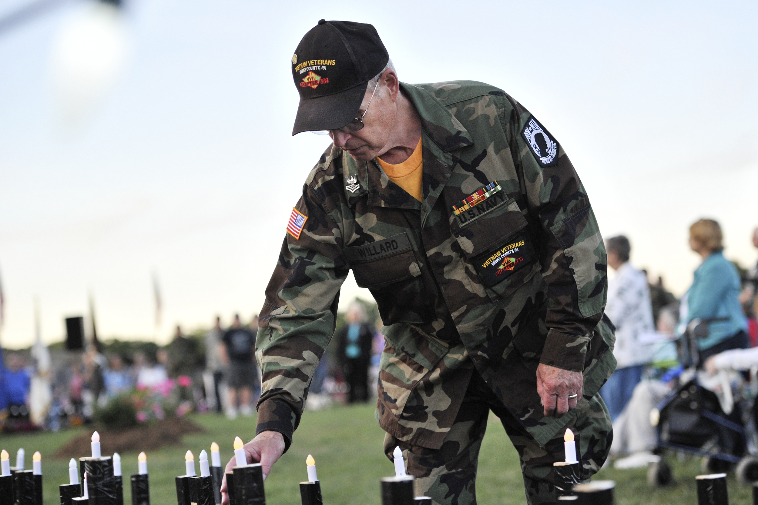 Joe Willard of Muhlenberg Township places a candle in memory of a fallen soldier at the candlelight ceremony on June 10, 2016, at the Moving Wall at Jim Dietrich Park in Muhlenberg Township, PA. (Sarah Stier: Reading Eagle)