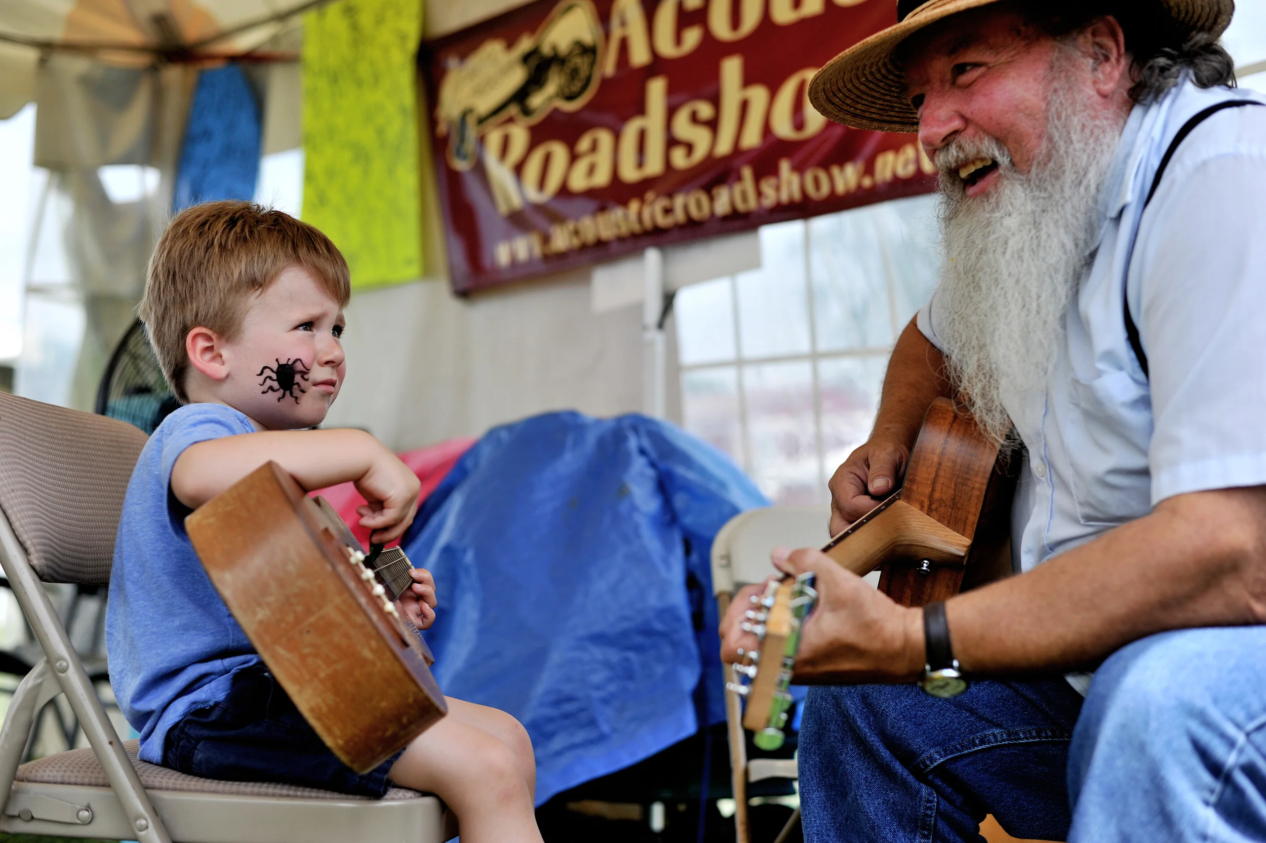 Lukas Cook, 2, of Branchburg, NJ, and Butch Imhoff of Hamburg play together at the Kutztown Folk Festival in Kutztown, PA, on July 5, 2016. (Reading Eagle: Sarah Stier)