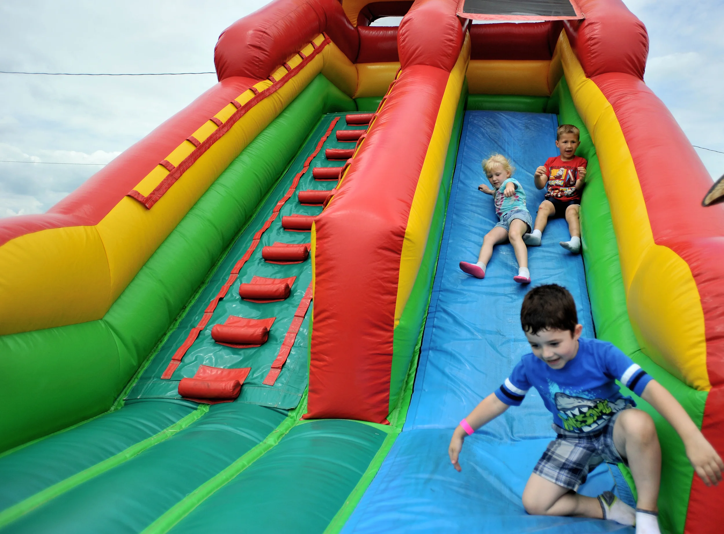 Daniel Gamble, 4, of McKeansburg, PA, slides down an inflatable slide at the Kutztown Folk Festival in Kutztown, PA, on July 4, 2016. Katie Repscher, 5, and her brother Benjamin, 7, of Bethlehem, follow closely behind. (Reading Eagle: Sarah Stier)
