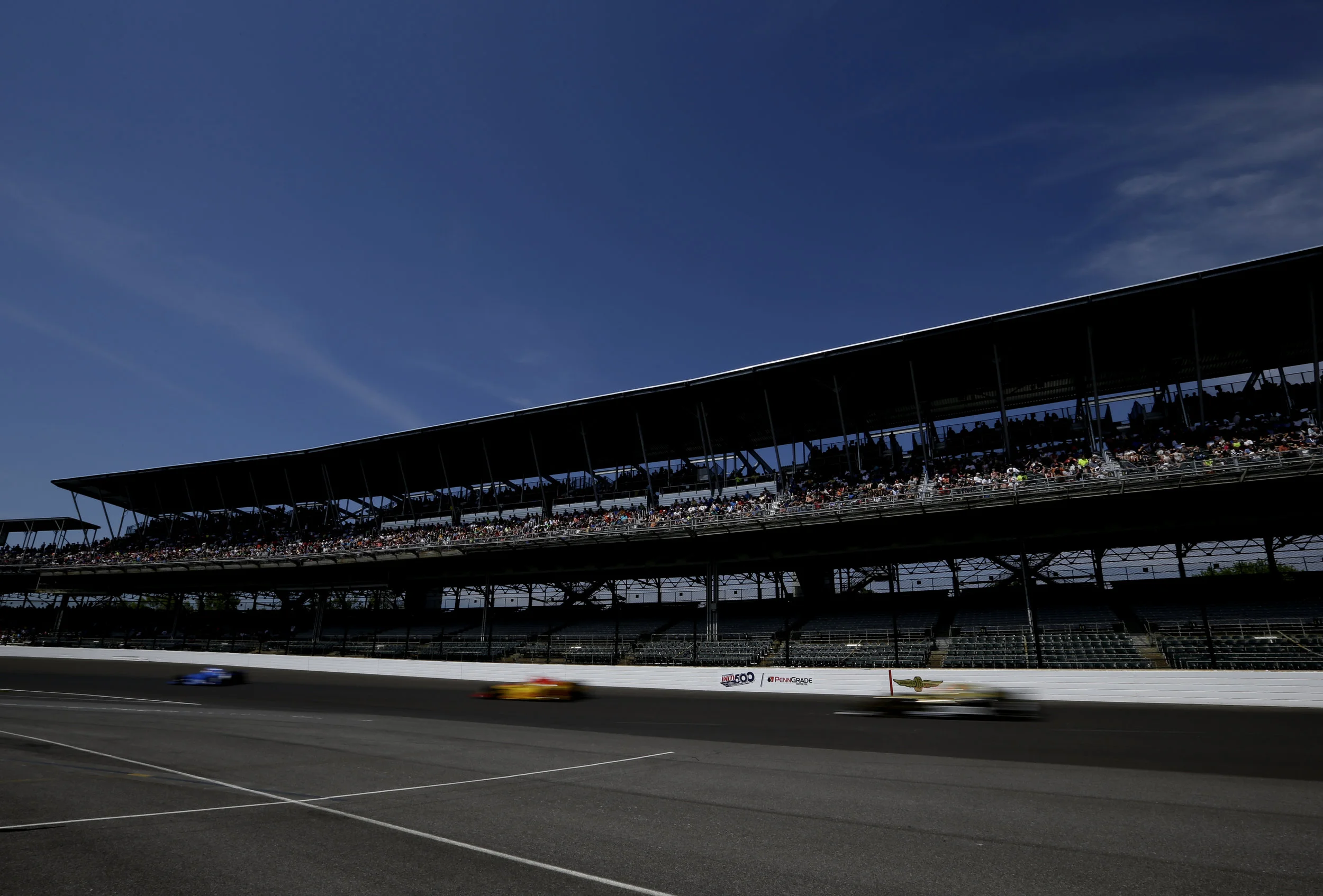 Cars fly by on the track during the practice race on Carb Day for the 101st running of the Indianapolis 500 at Indianapolis Motor Speedway on Friday, May 26, 2017.