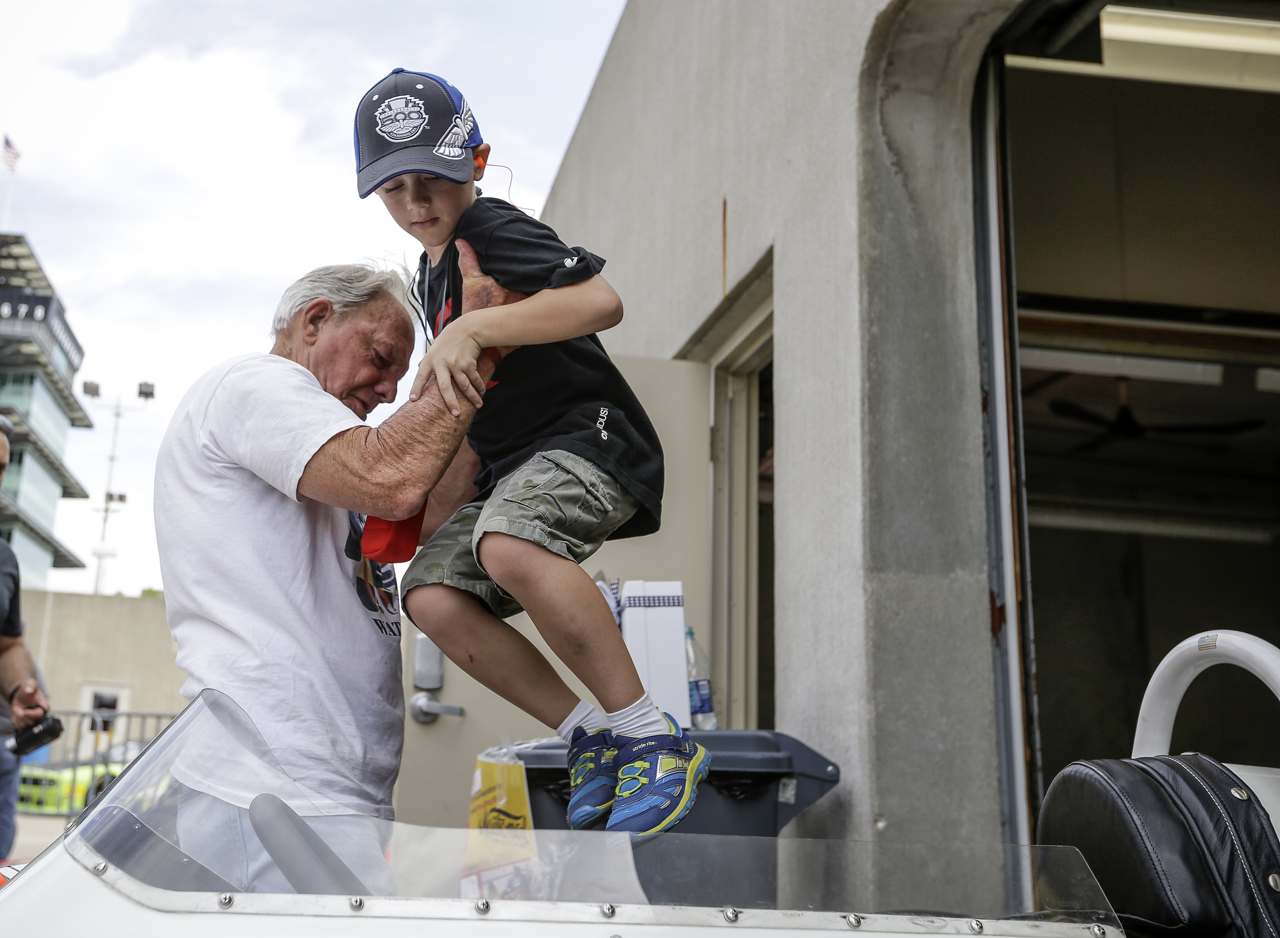 Bud Taylor hoists Andrew Lewis, 7, into his car in at the SVRA Brickyard Vintage Race at Indianapolis Motor Speedway on Saturday, June 17, 2017.