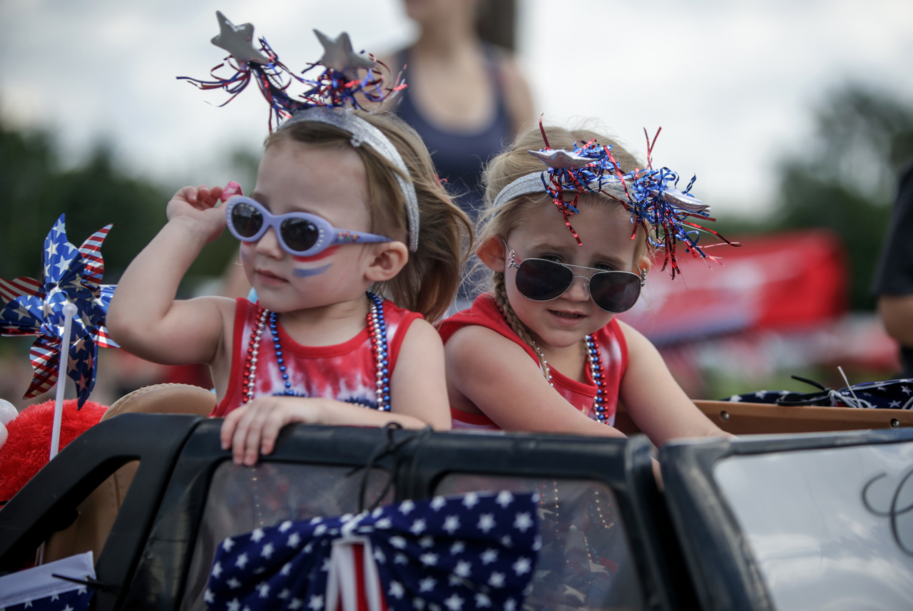 Two girls drive a mini Cadillac as part of the parade at the Freedom Festival in Greenwood, Ind., on Saturday, June 24, 2017.