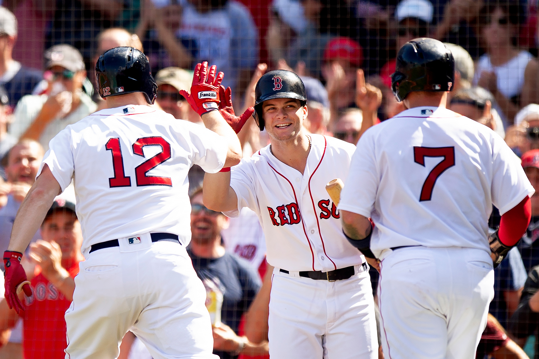  Boston Red Sox outfielder Brock Holt and catcher Christian Vasquez high-five outfielder Andrew Benintendi during the game against New York Mets at Fenway Park in Boston, Massachusetts, on Sunday, September 16, 2018. 