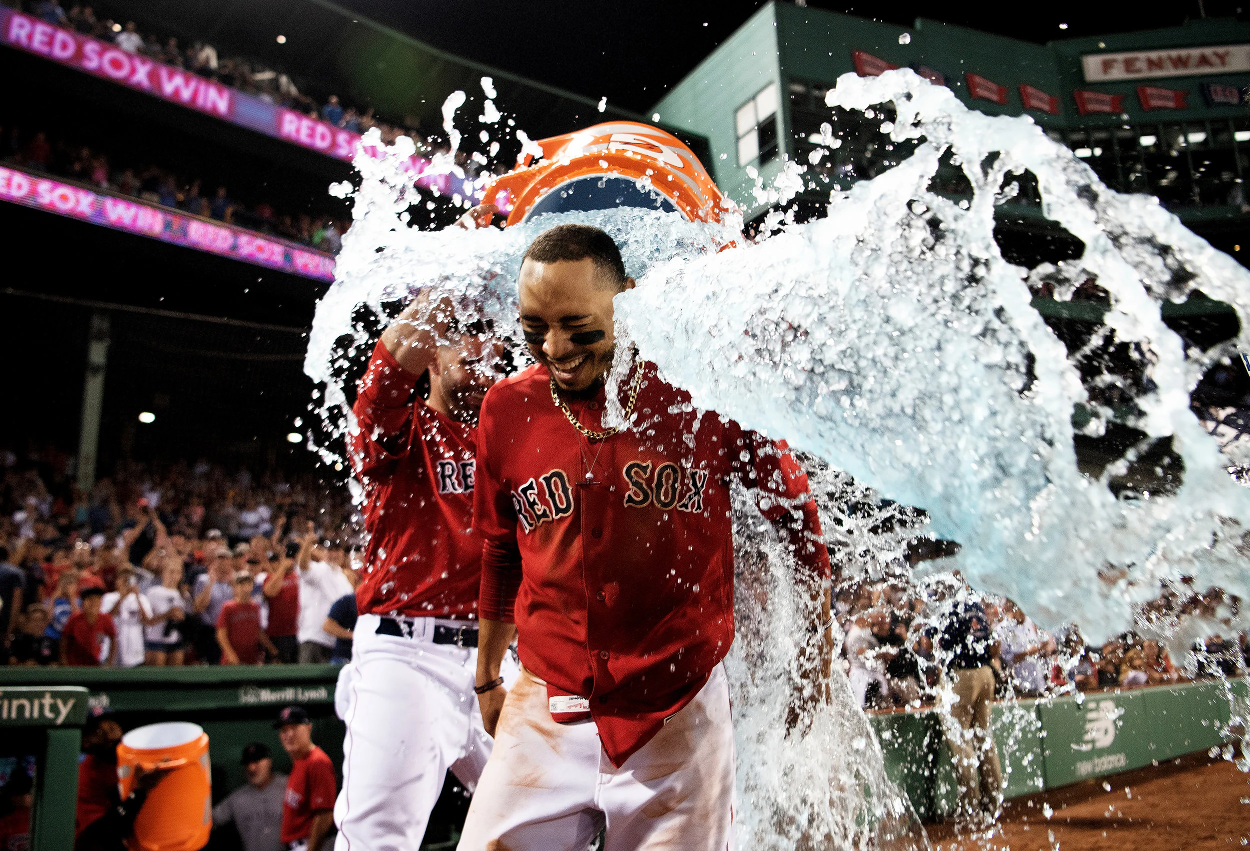 Boston Red Sox outfielder Mookie Betts receives a Gatorade shower after hitting a home run to end the game in the 10th inning during the game against the Minnesota Twins at Fenway Park in Boston, Massachusetts on Friday, July 27, 2018.