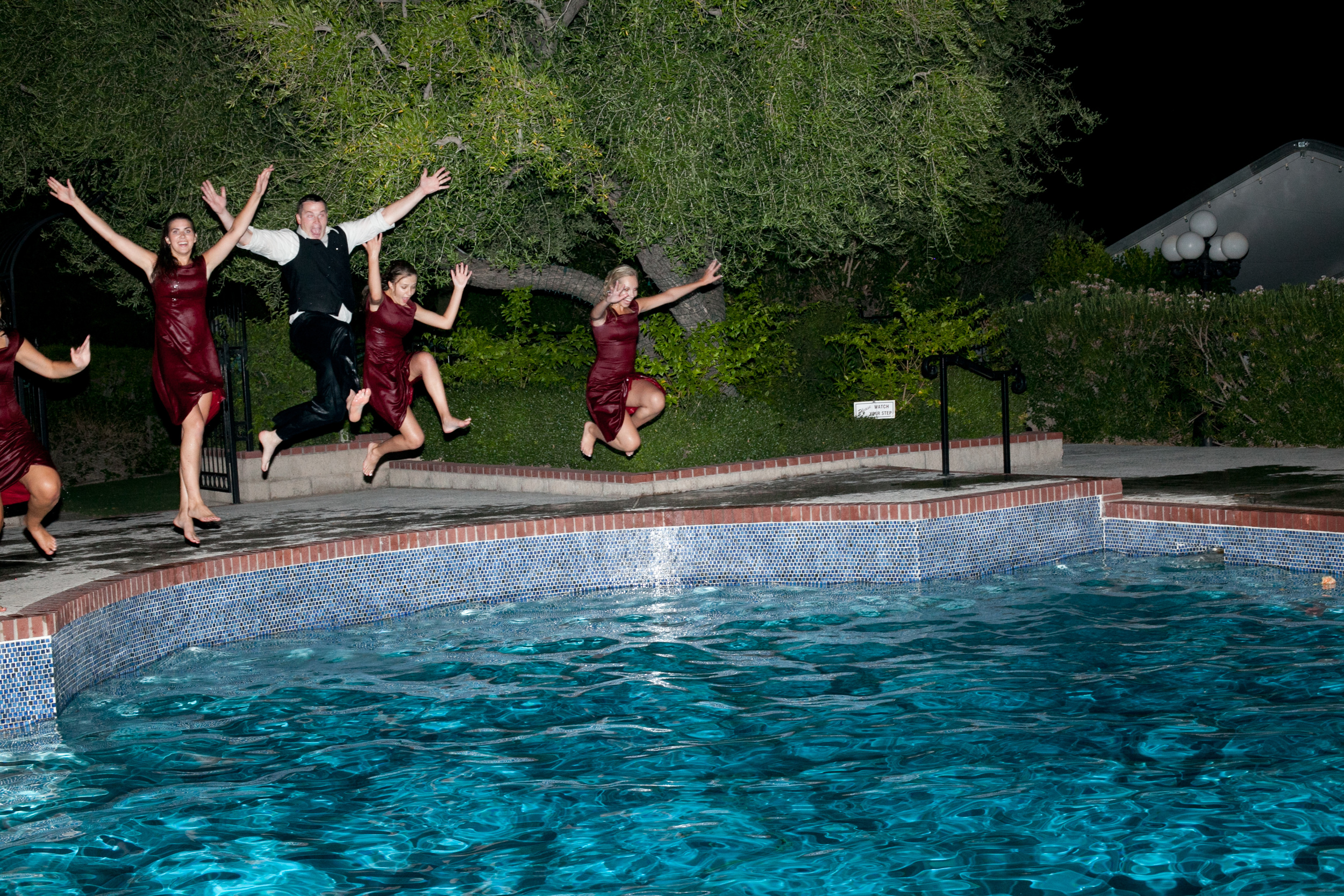 Jumping into a pool with the bridesmaids after a long hot wedding day.