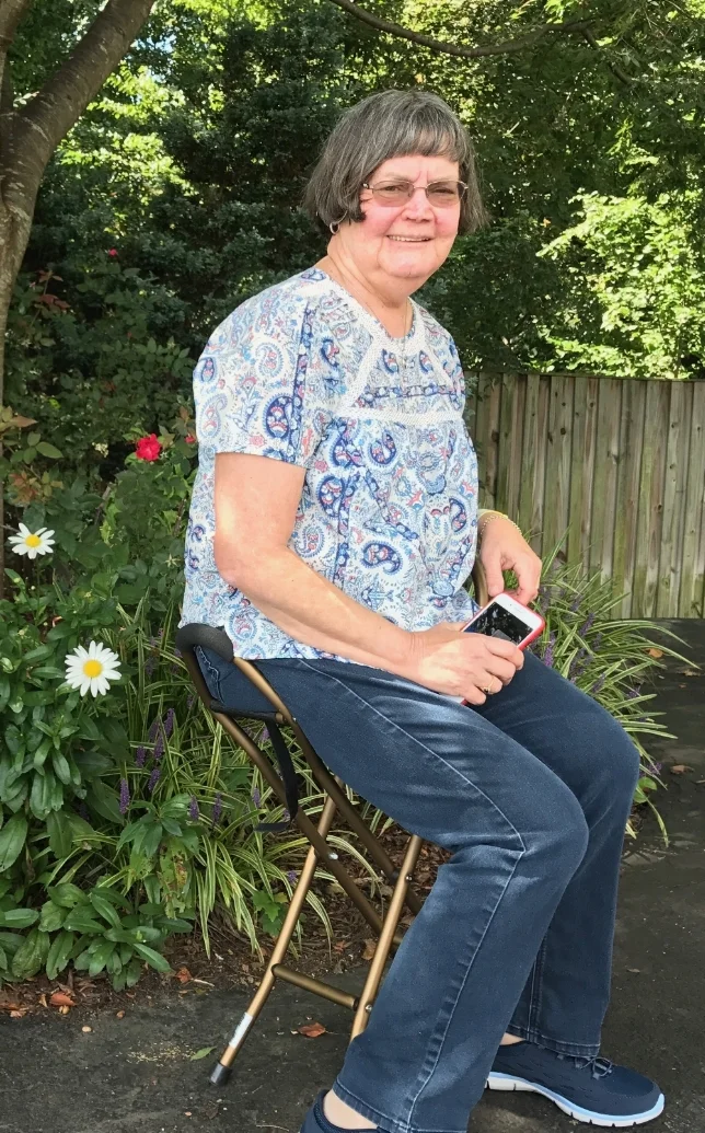 pat on her portable Stool