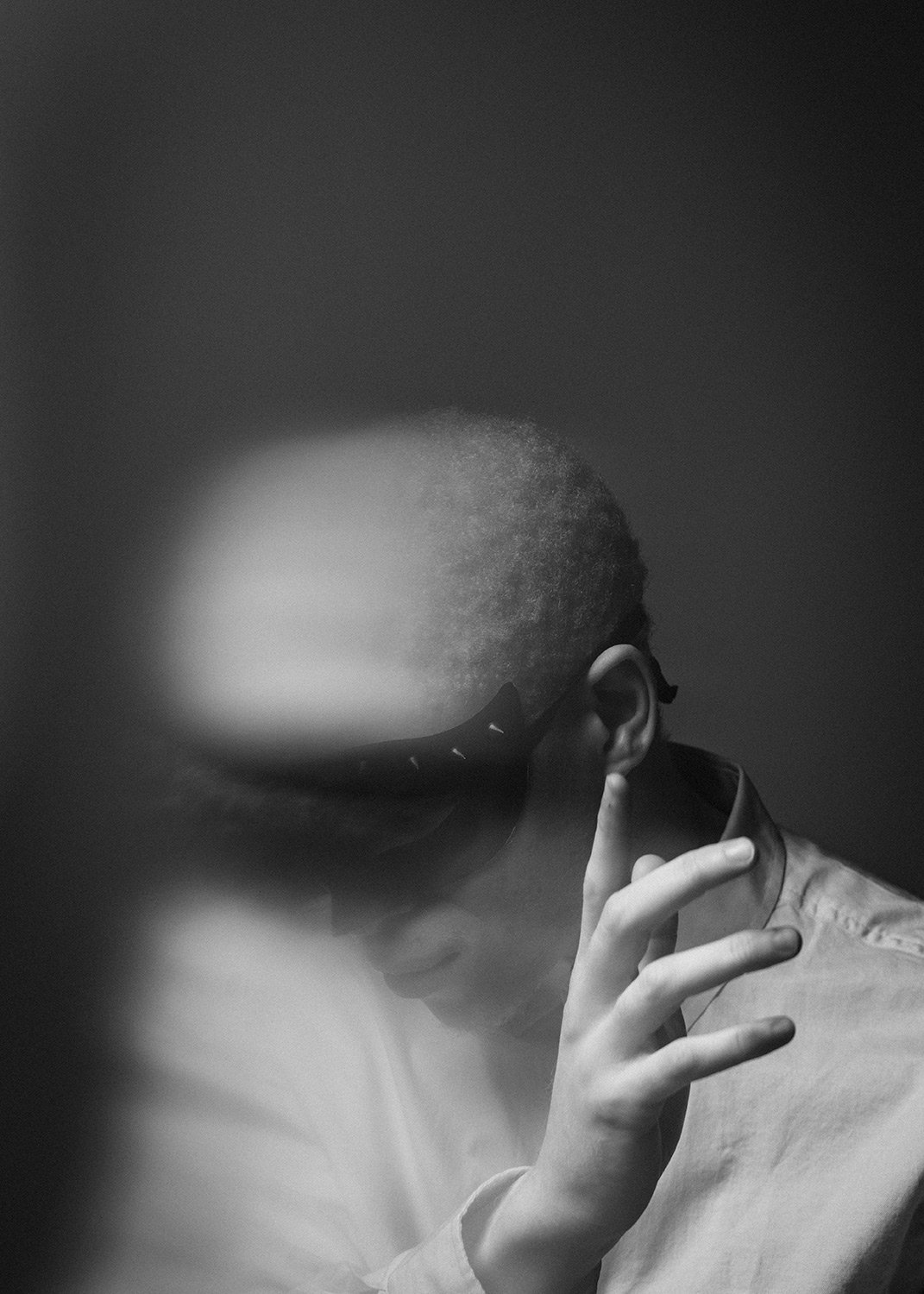  Dramatic, high-contrast black and white conceptual portrait by MANICPROJECT featuring a subject holding a vintage telephone receiver to their ear, their face partially obscured to create an eerie, anonymous silhouette. This cinematic fine art photog