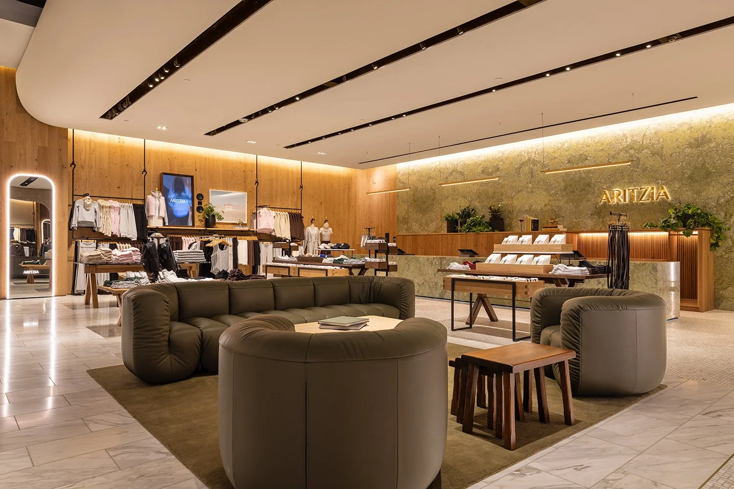 Commercial interior photography capturing the sophisticated lounge area of the Aritzia boutique, featuring upscale seating and curated modern finishes designed for high-end retail environments 
