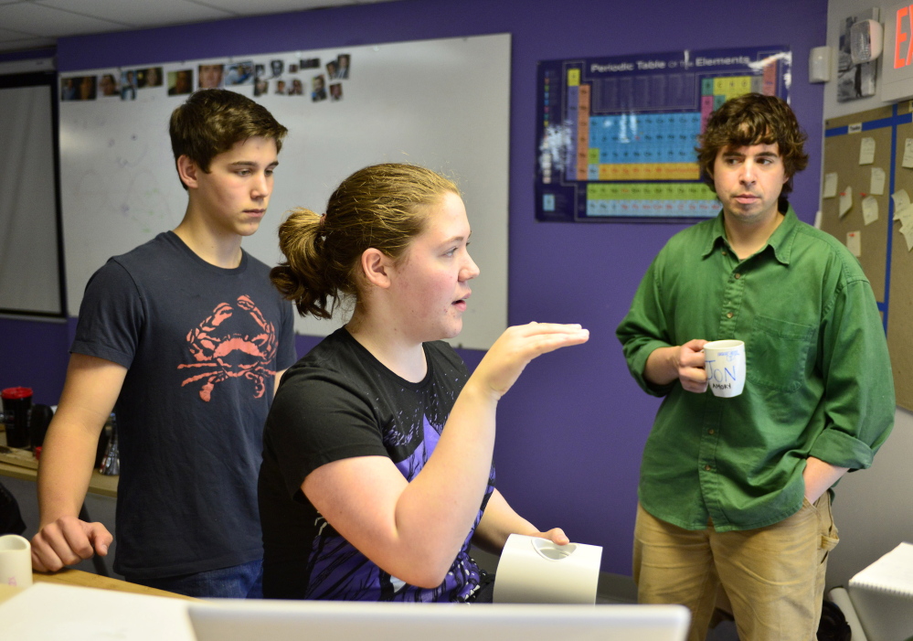 Baxter Academy student Erin Whitney talks about her team’s engineering project as student Caedan Holdan, left, and engineering teacher Jonathan Amory listen