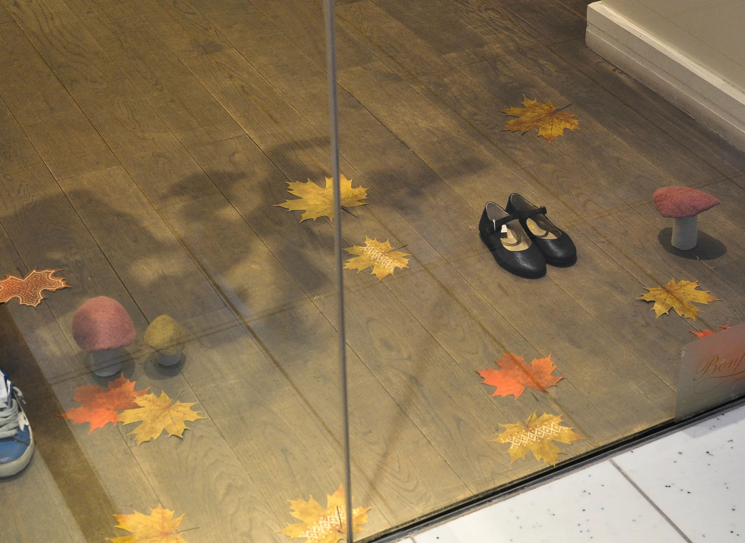 BONPOINT KIDS Real autumn leaves with varying painted tribal patterns on them sat beautifully next to woolen hand-felted mushrooms. A soft, warm and natural touch to compliment their Autumn/Winter collection which hung on tree branches above.
