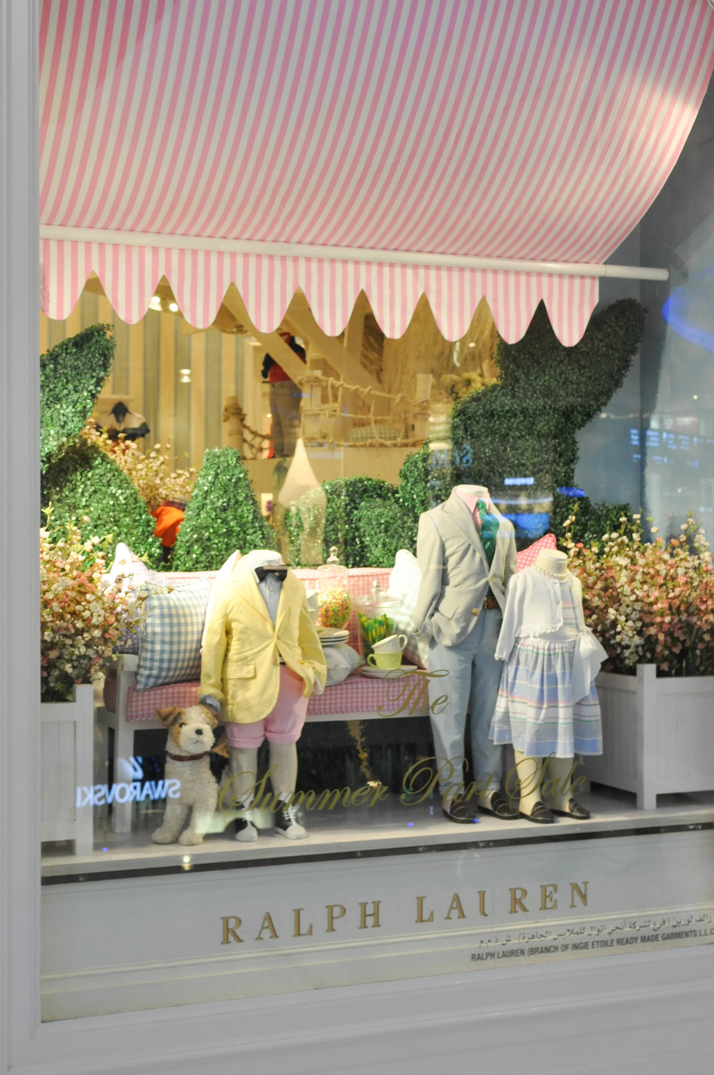 RALPH LAUREN KIDS Stripes, cheques, and hedged plants set the scene for this cute, posh outdoor tea-party themed display. NB. The bow tie with shorts look on the left, reminded me of a little boy I saw dressed similar at a wedding in Italy where he wore a bow tie (without the jacket), together with shorts and sneaker boots. Very cute, quirky look for a little boy!