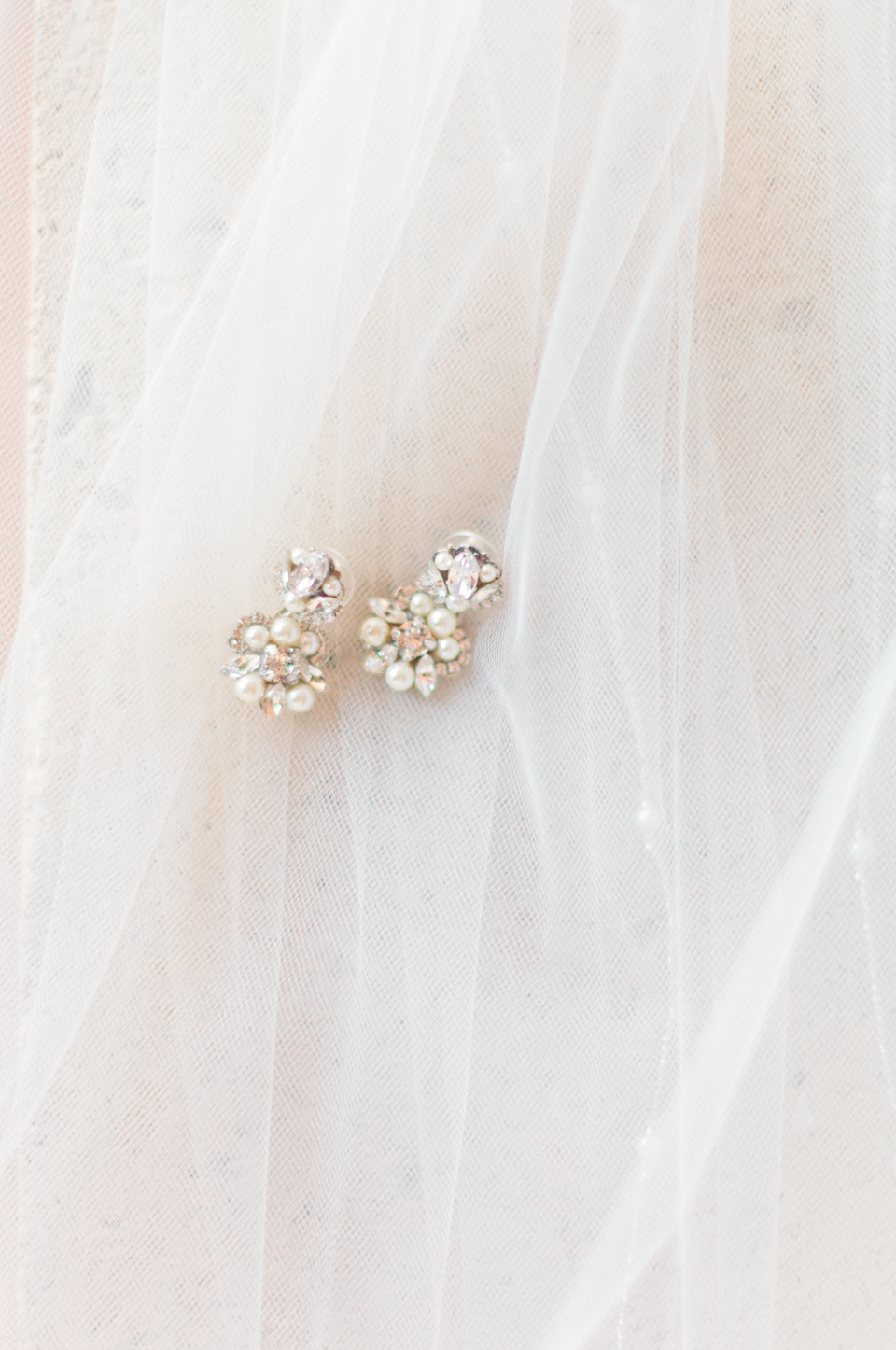Image of diamond earrings laying on a bridal veil at TPC Sawgrass in Ponte Vedra, Florida