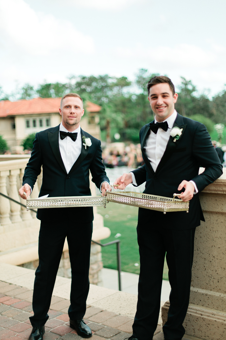 Picture of ushers at a wedding, wearing black tuxedos handing out programs at TPC Sawgrass in Ponte Vedra, Florida