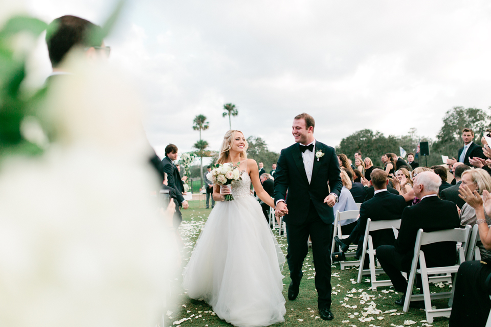 Image of the bride and groom exiting their wedding ceremony at TPC Sawgrass in Ponte Vedra, Florida