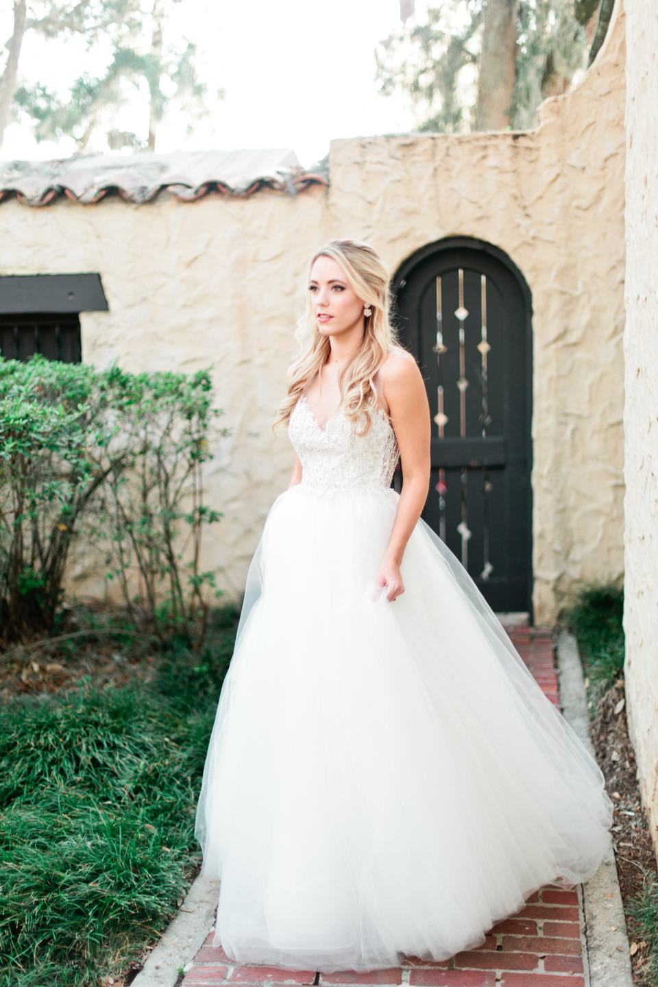 Image of bride in her Calvet Couture wedding gown walking and looking off into the distance at the Epping Forest Yacht Club