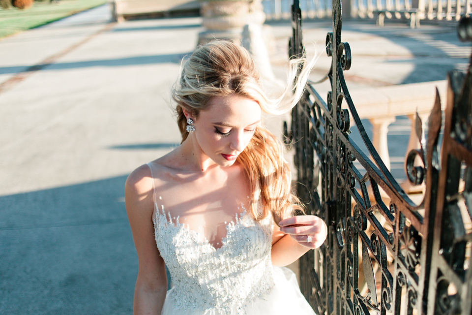 Image of a bride at an iron gate, glancing down at the Epping Forest Yacht Club in Jacksonville, Florida