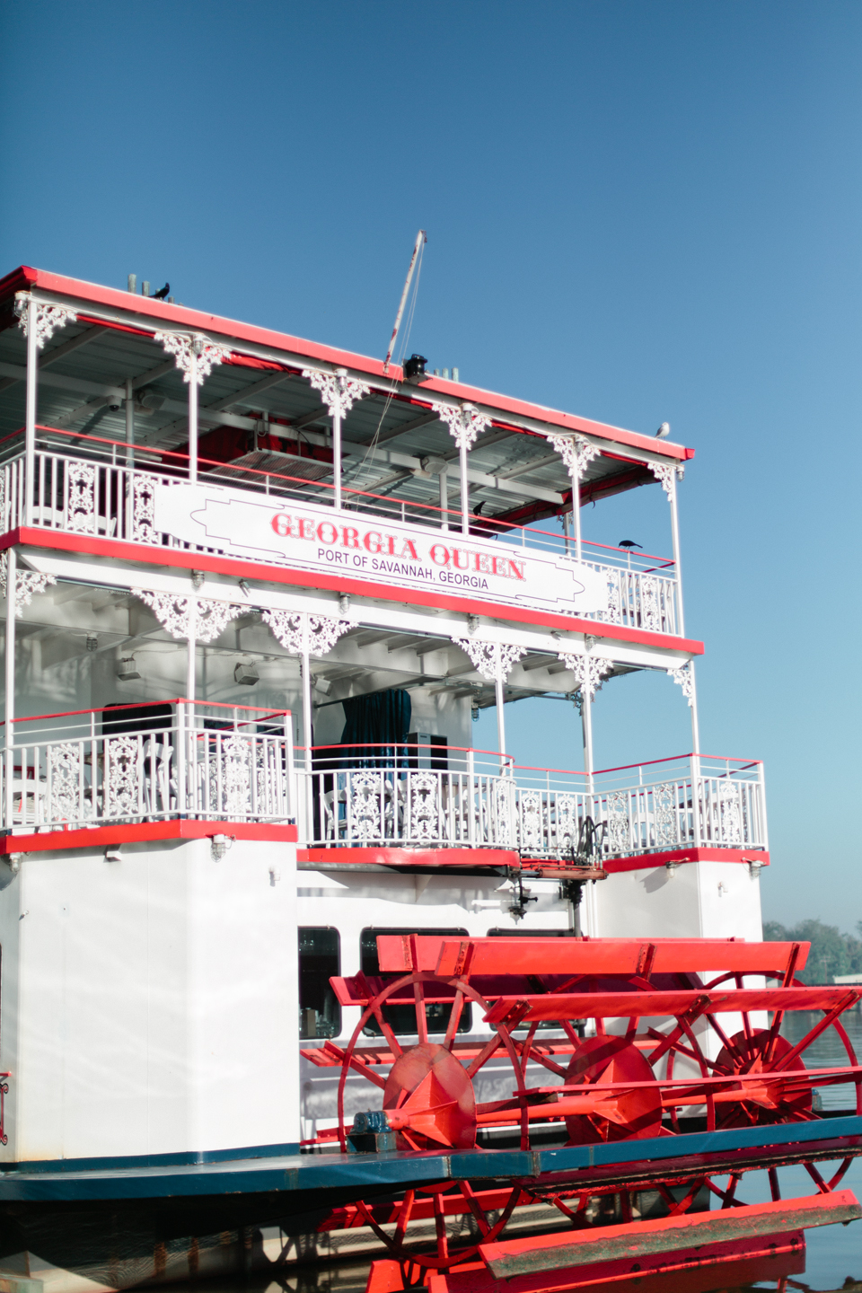 Picture of a white and red riverboat docked on East River Street in historic downtown Savannah, Georgia.
