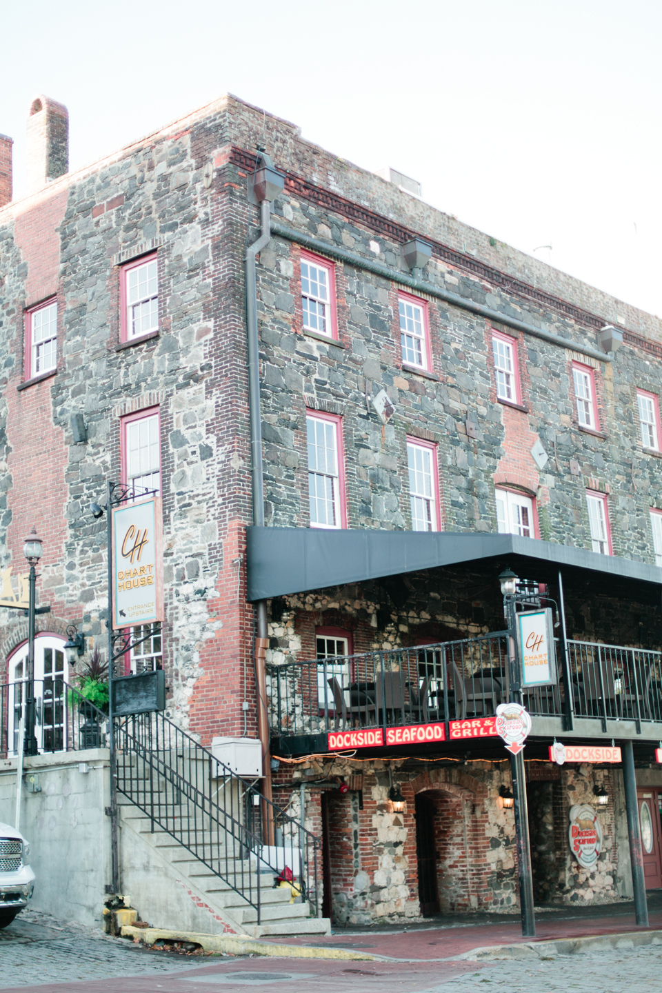 Image of buildings on East River Street in downtown historic Savannah, Georgia.  This is a four story stone building with steps.