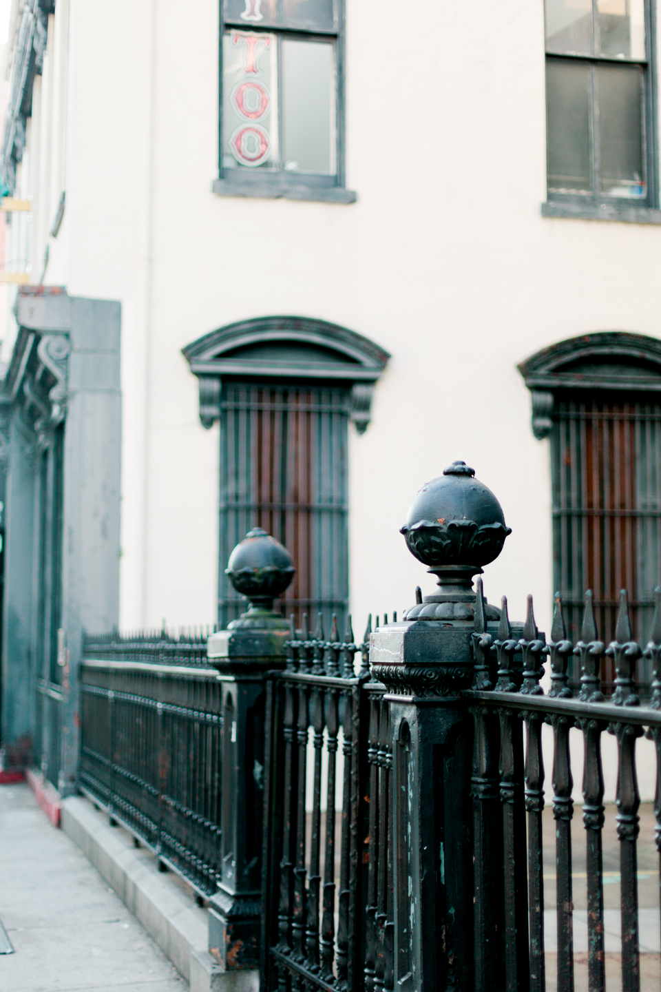 Image of downtown historic Savannah, Georgia.  Iron fence with architectural posts and a historic building beside it.