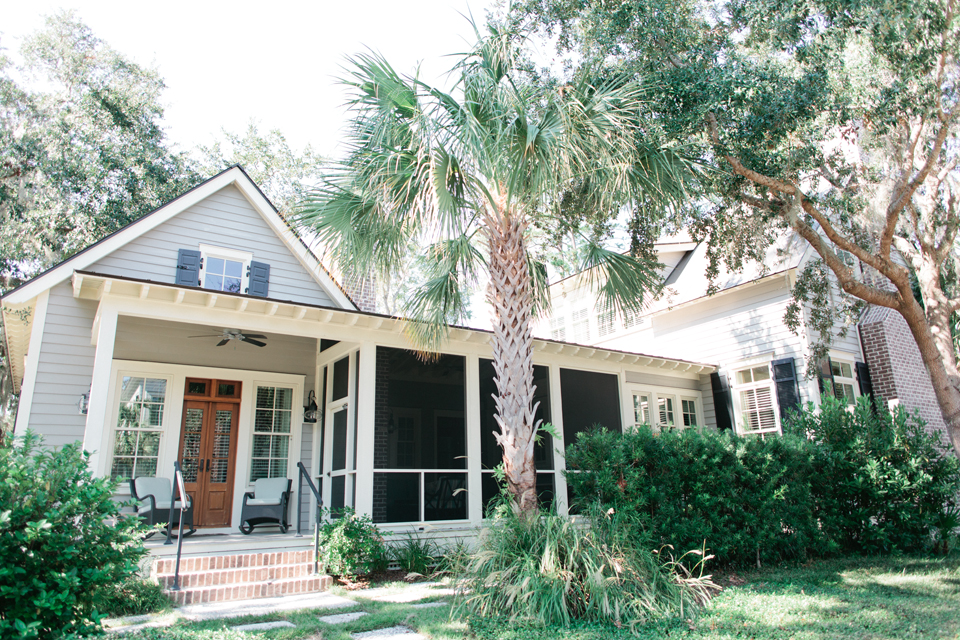 Image of a coastal South Carolina house in Montage Palmetto Bluff.  One story, pale blue, with a front porch.