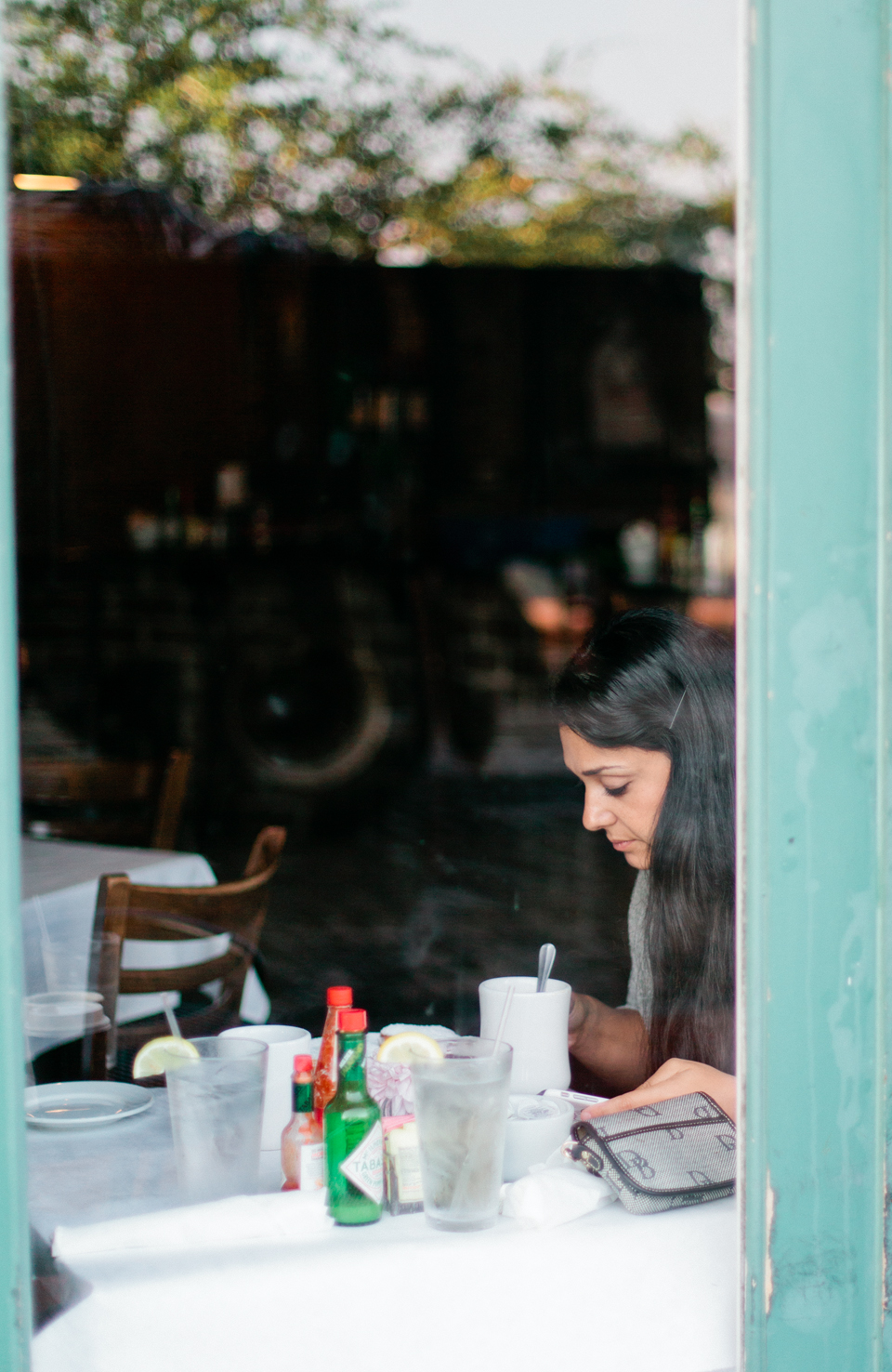 Image of Rana of Roohi Photography through a cafe window in historic downtown Savannah, Georgia.