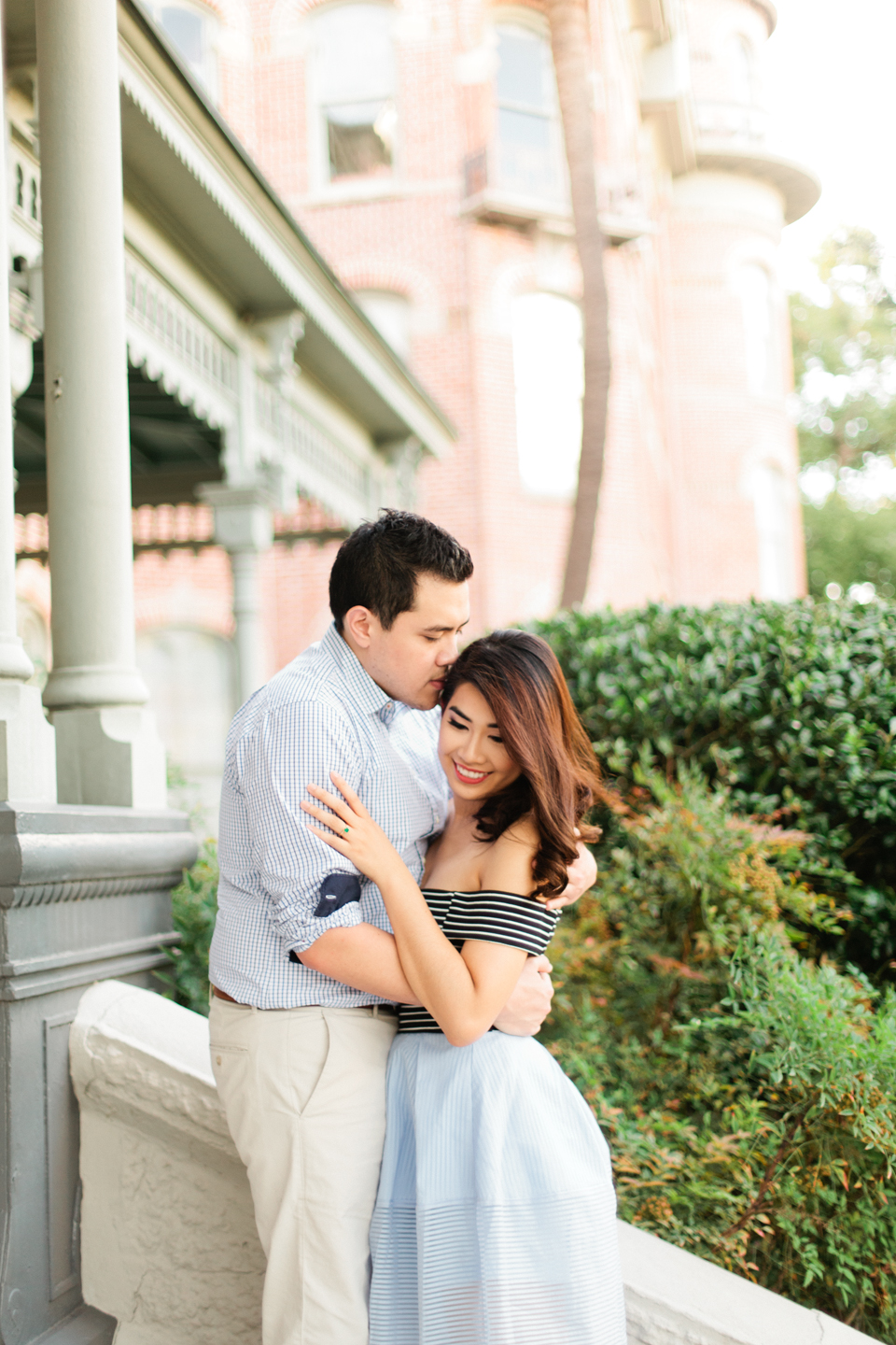 Image of engagement portraits on the steps of the Henry B Plant museum in Tampa, Florida.  The couple is in a romantic embrace.  