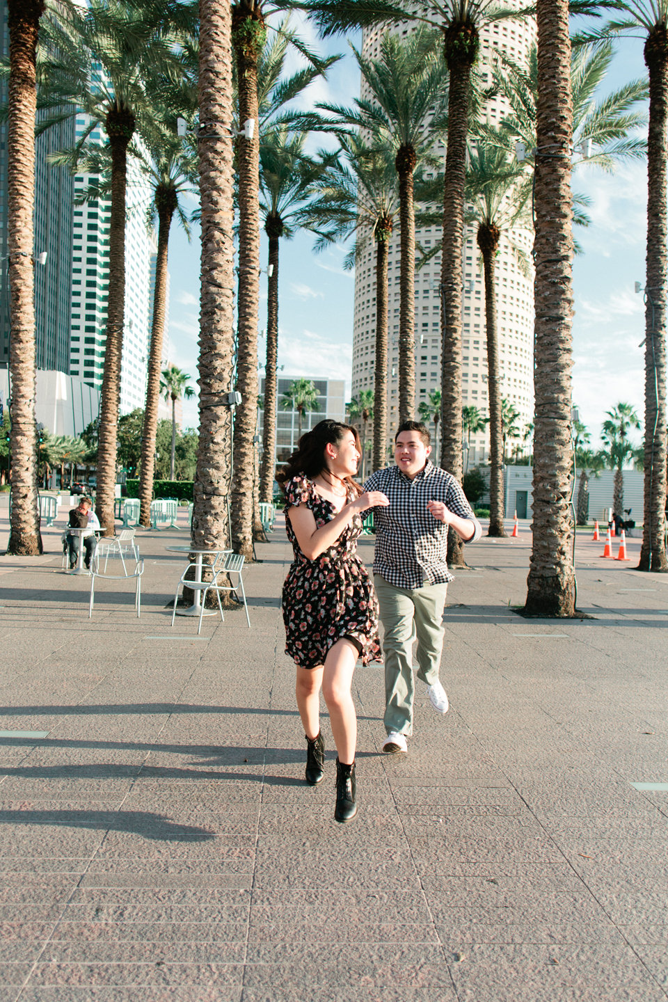 Image of an engaged couple running playfully at Curtis Hixon Waterfront Park.