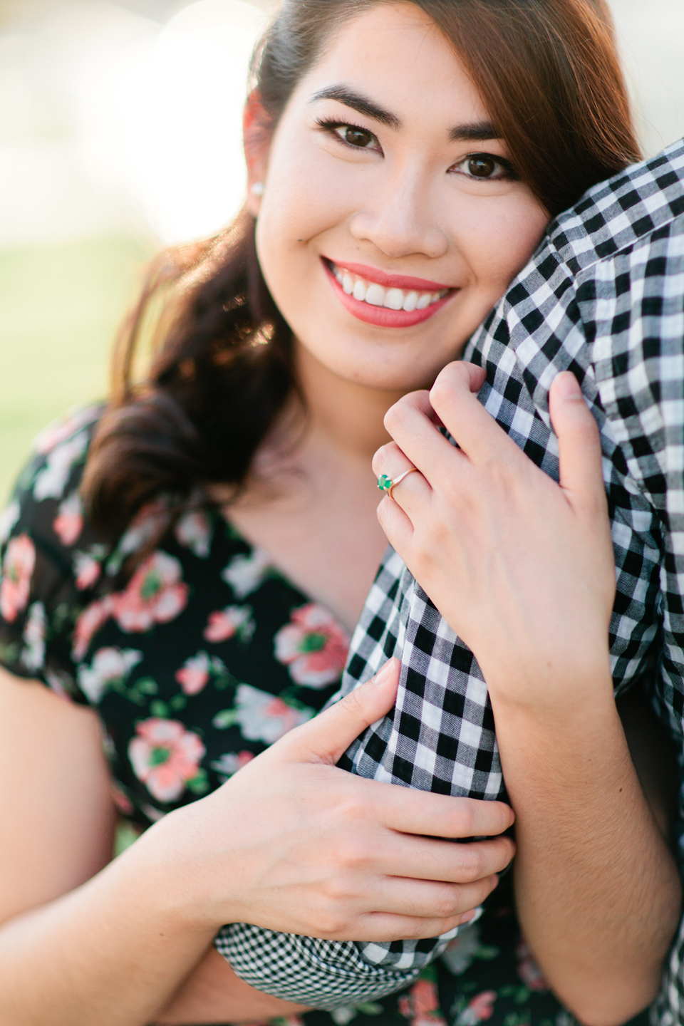 Image of a beautiful woman smiling while holding the arm of her fiance.  This engaged couple is at Curtis Hixon Waterfront Park in downtown Tampa, Florida.