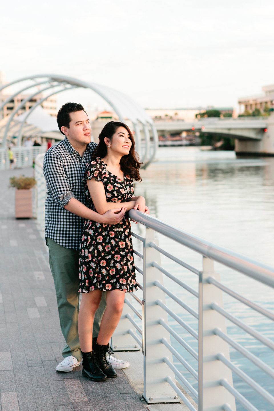 Image of an engaged couple looking out on the riverwalk in downtown Tampa at Curtis Hixon Waterfront Park.   