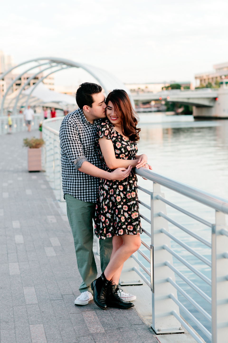 Picture of an engaged couple embracing on the Tampa Riverwalk in downtown Tampa at Curtis Hixon Waterfront Park. 