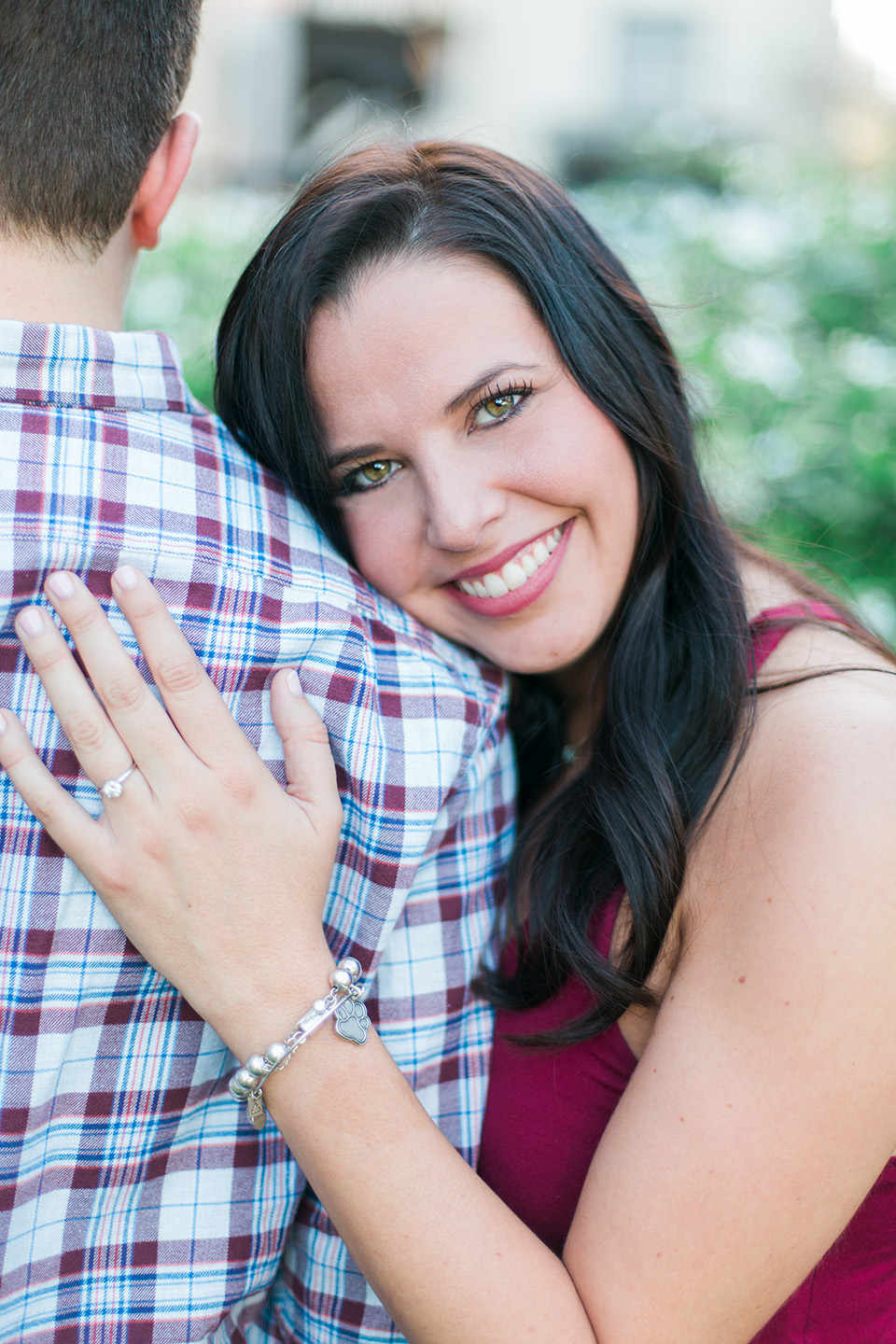 Image of an engaged couple in downtown Orlando, Florida.  She is smiling radiantly while cuddling into her fiance.