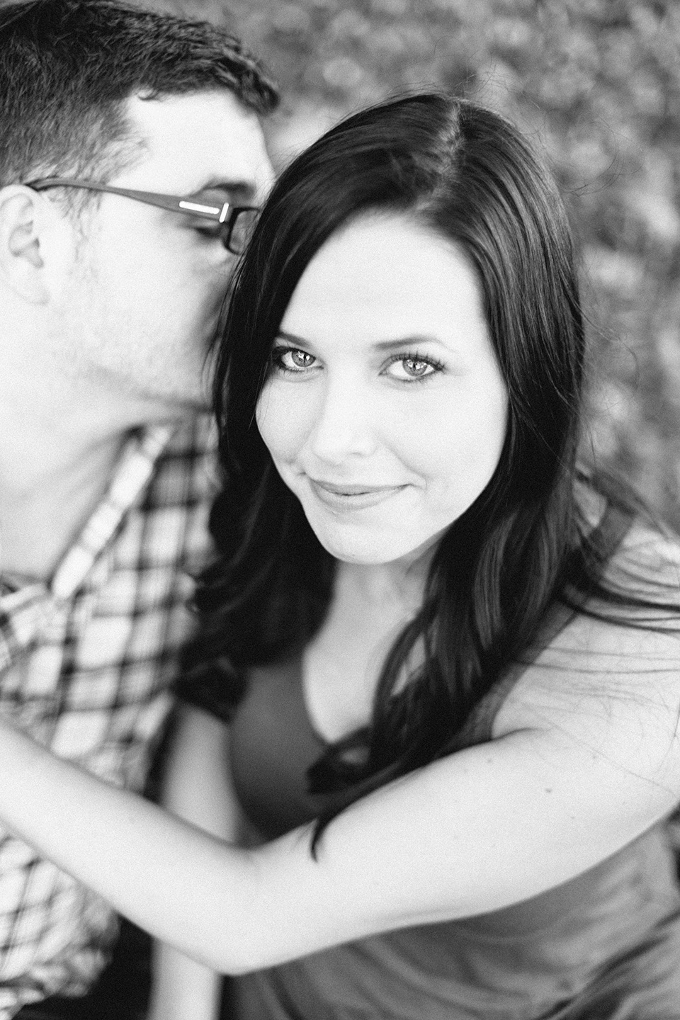 Picture of an engaged couple in downtown Orlando.  The woman is looking into the camera while holding her fiance.  The image is in black and white.