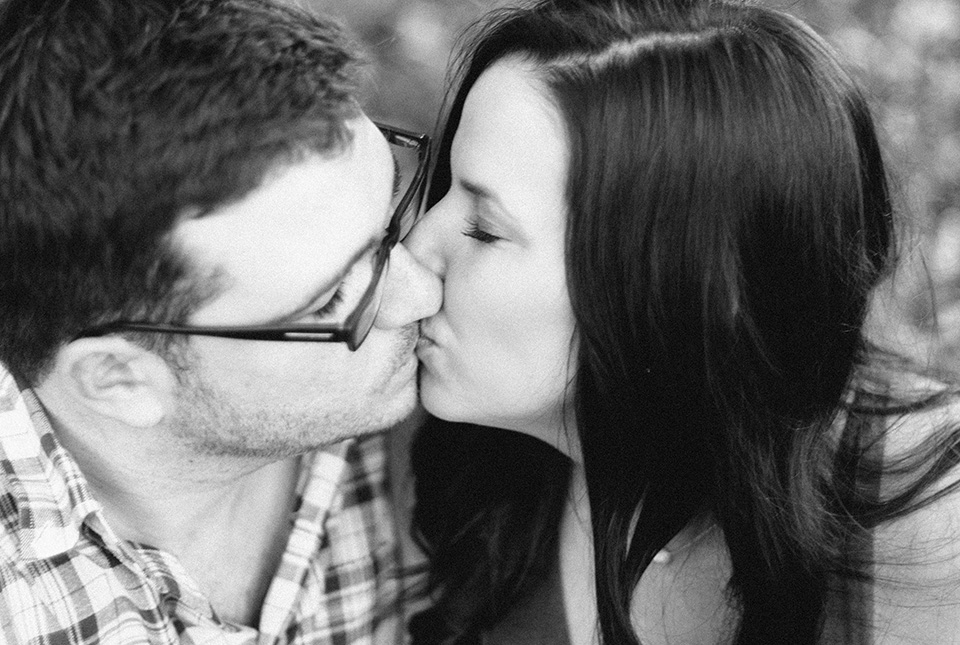 A black and white picture of an engaged couple kissing in downtown Orlando, Florida.