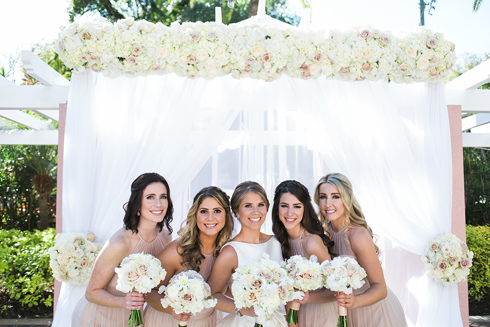 Bride with her bridesmaids and a floral canopy on a wedding day at The Vinoy in St. Pete, Florida | Debra Eby Photography Co.