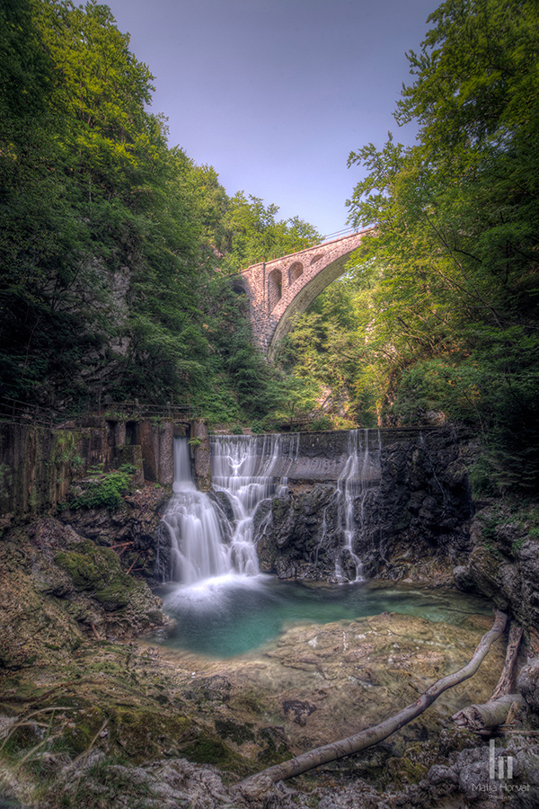 Single-arch stone bridge of the Bohinj railway over small dam