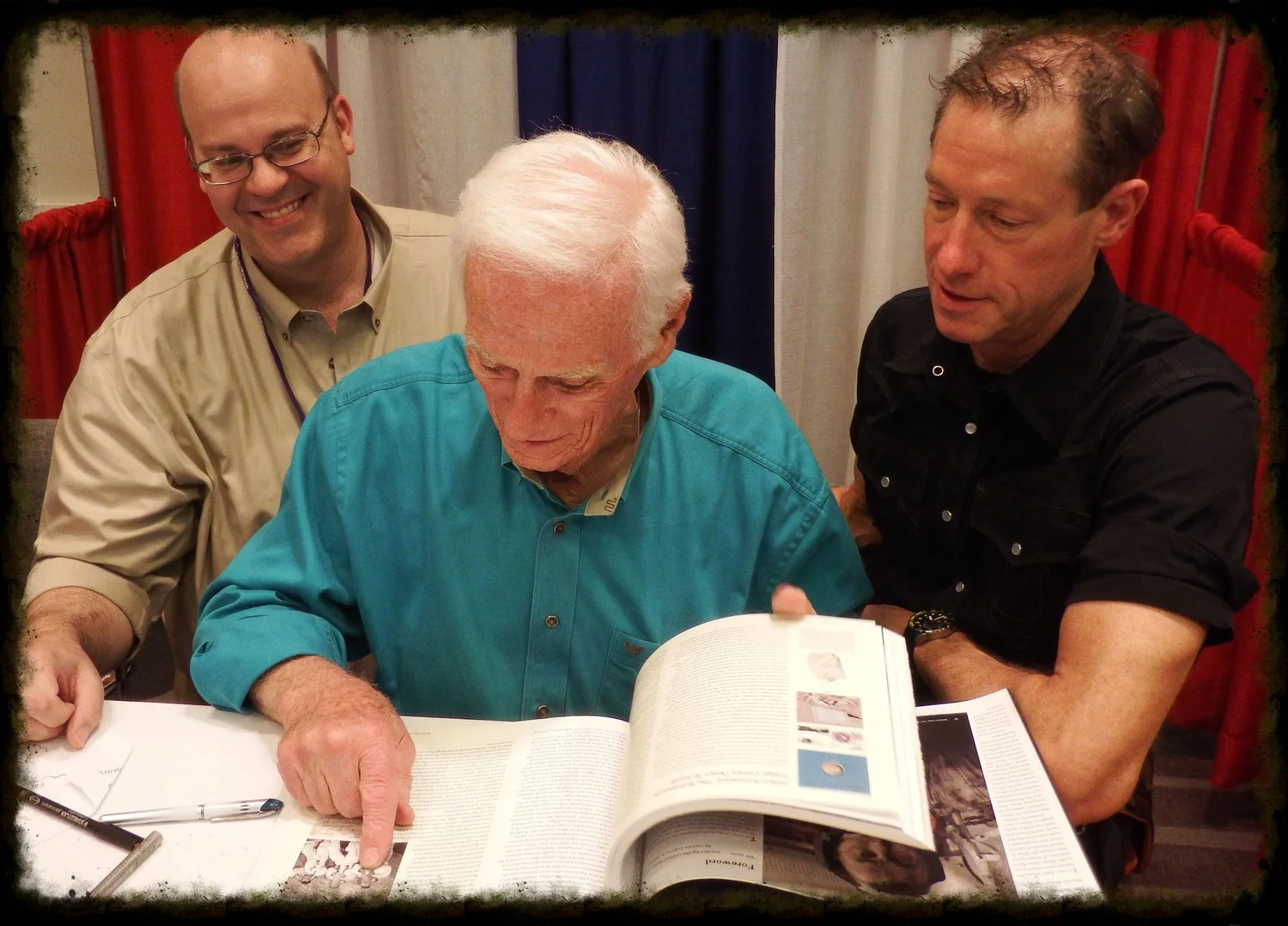 Richard Jurek (left), Astronaut Gene Cernan (center), and David Meerman Scott (right), enjoy flipping through Marketing the Moon with Gene and discussing some of his favorite sections in the book.