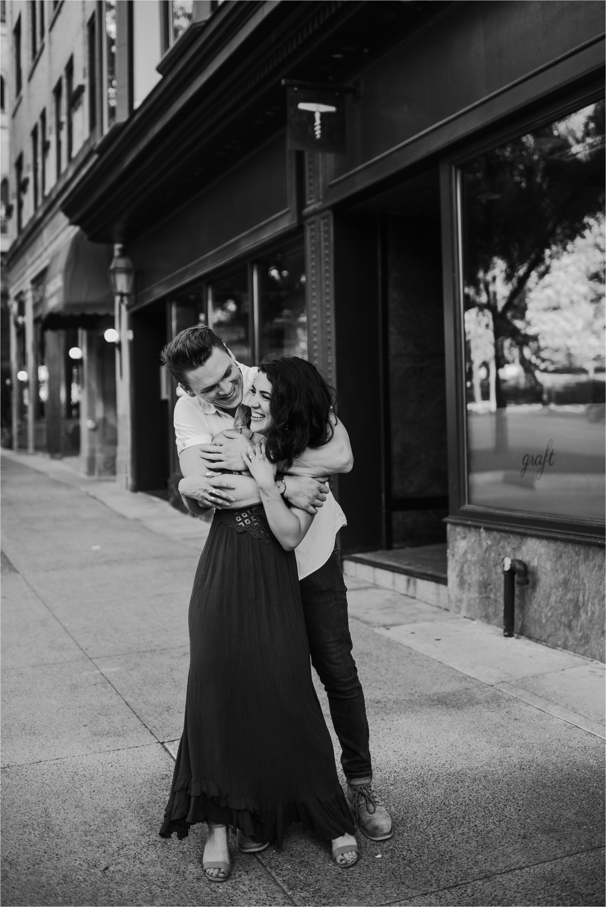  madison wisconsin state street downtown engagement photos engaged photography photos couple session wedding urban black and white sidewalk hug kiss smile happy 