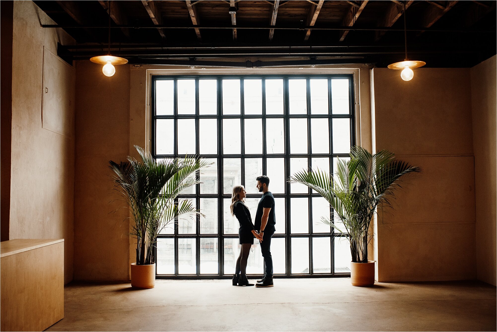  couple standing in front of large window at each other event space in minneapolis minnesota 