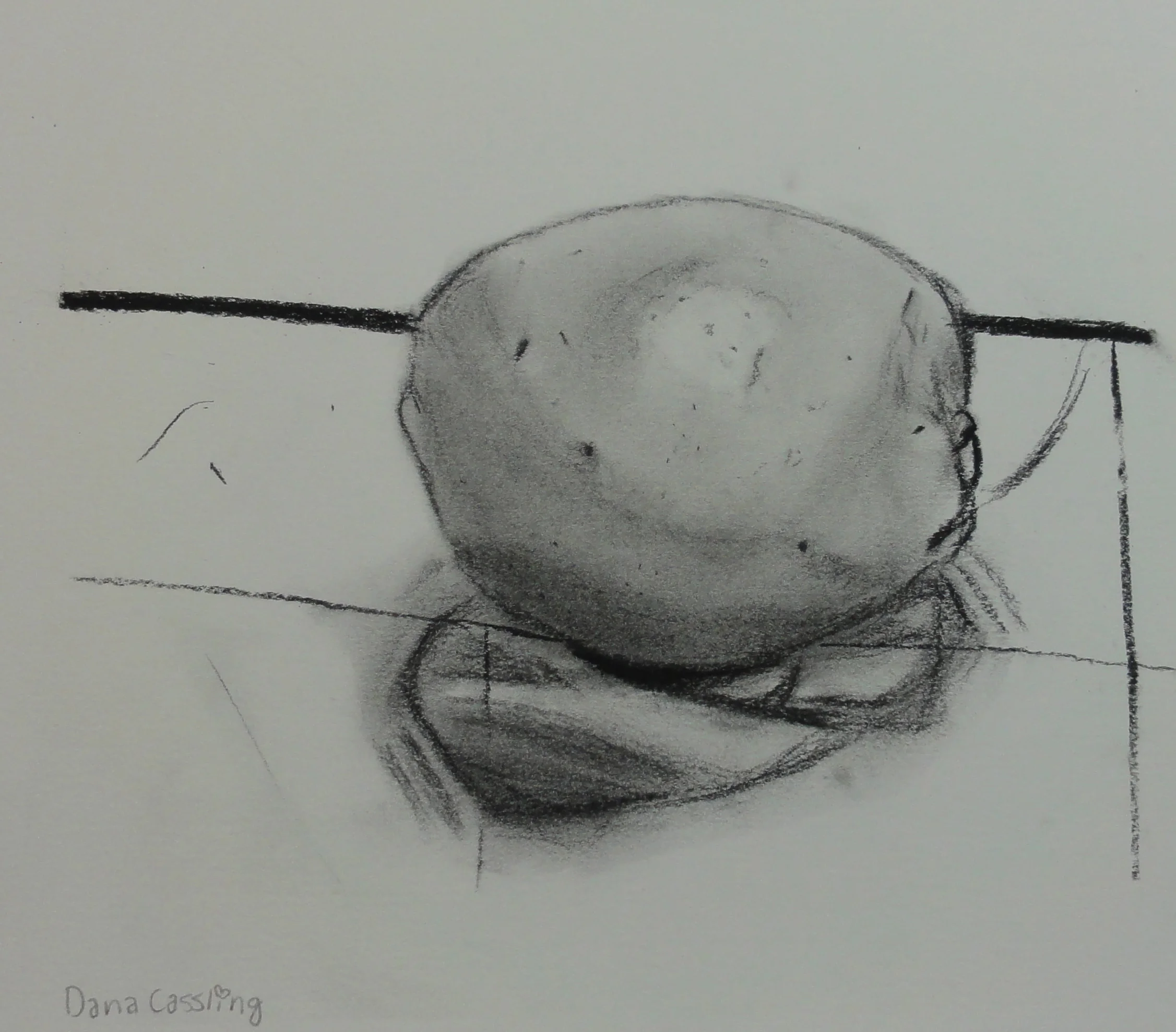  An orange drawn under a fluorescent lighting on a hard surface using charcoal. 