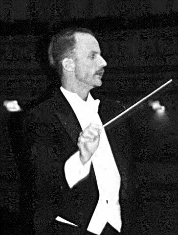 Tall, thin Dean Johnson in a tux conducting an orchestra.