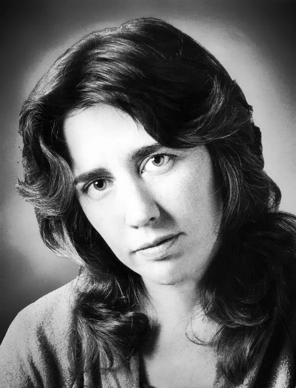 A headshot of Joan tower from the 60s, she has long dark hair and dark eyes.