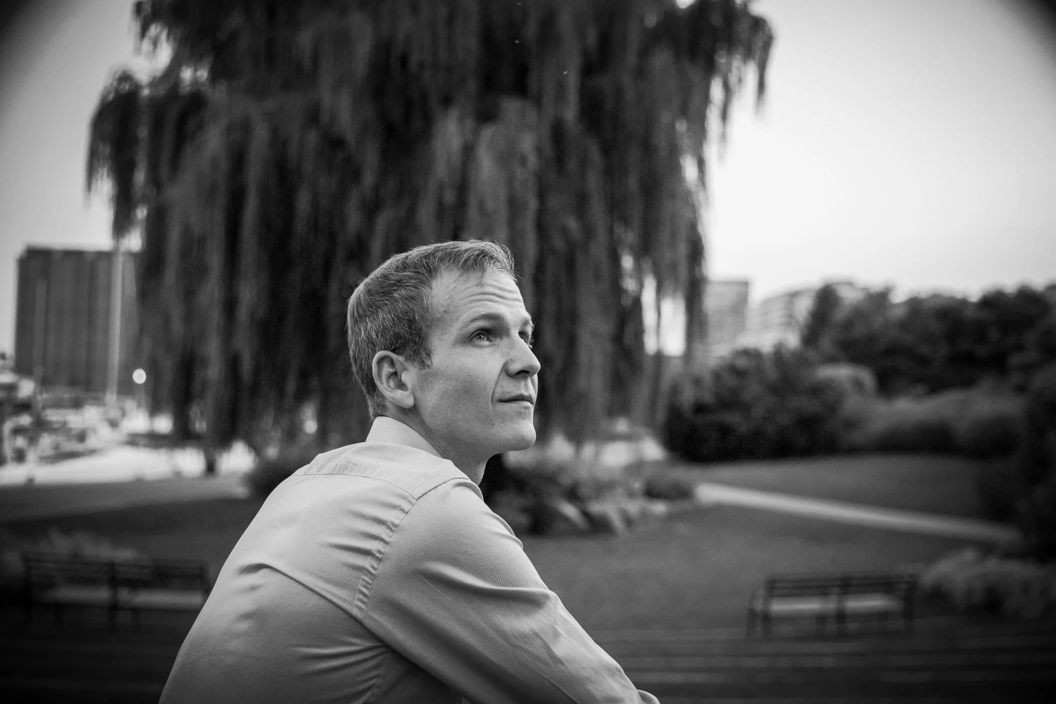 Sandy-haired Brian Harman crouched in front of a willow tree.