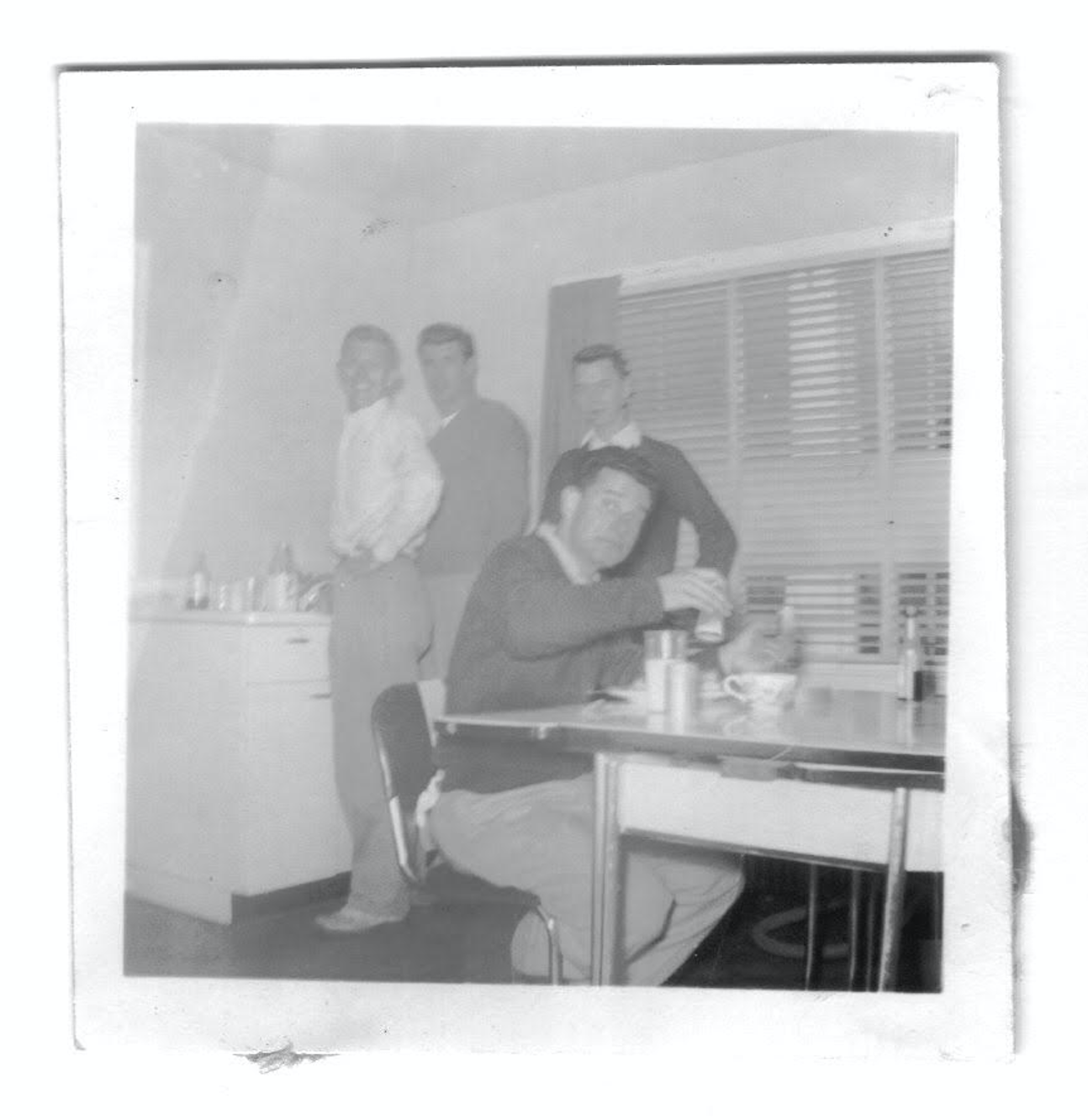  Charlie Bashara enjoying a "home cooked" meal at Deek's house on N. Main Street. Brothers Frank Jordan, Tom Richards, and Pete _____ in background. 