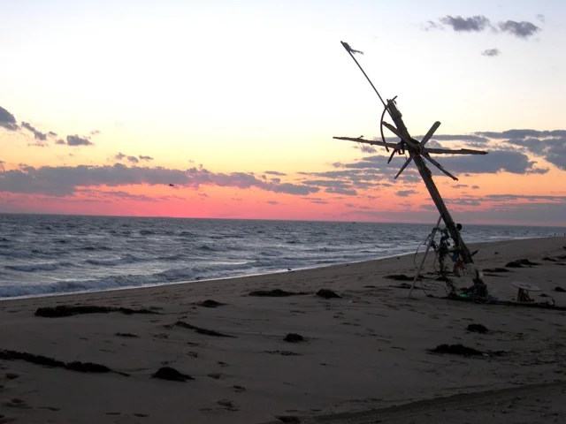 The beach and "beach art" at sunset. Because the tip of Cape Cod curves around, one sees the sun set over water. An unusual sight on the east coast!