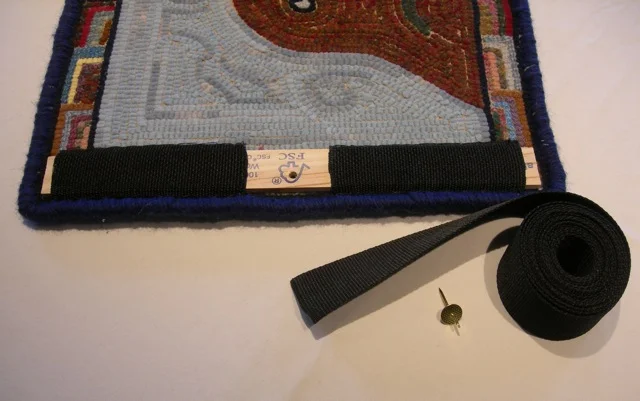 A visual of how the back of a rug is prepared for hanging.